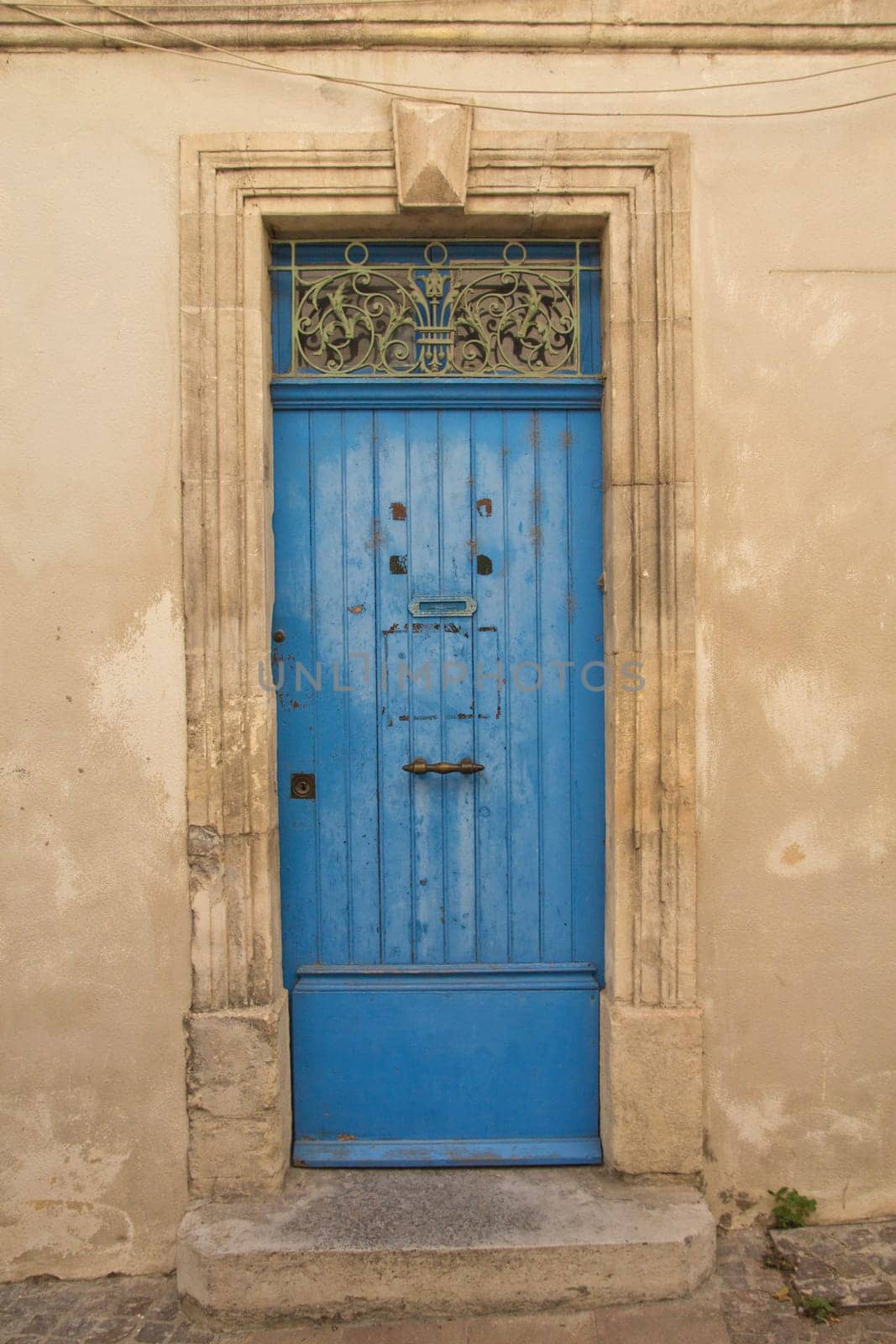 Old blue wooden entrance door to the house. Mediterranean architecture.