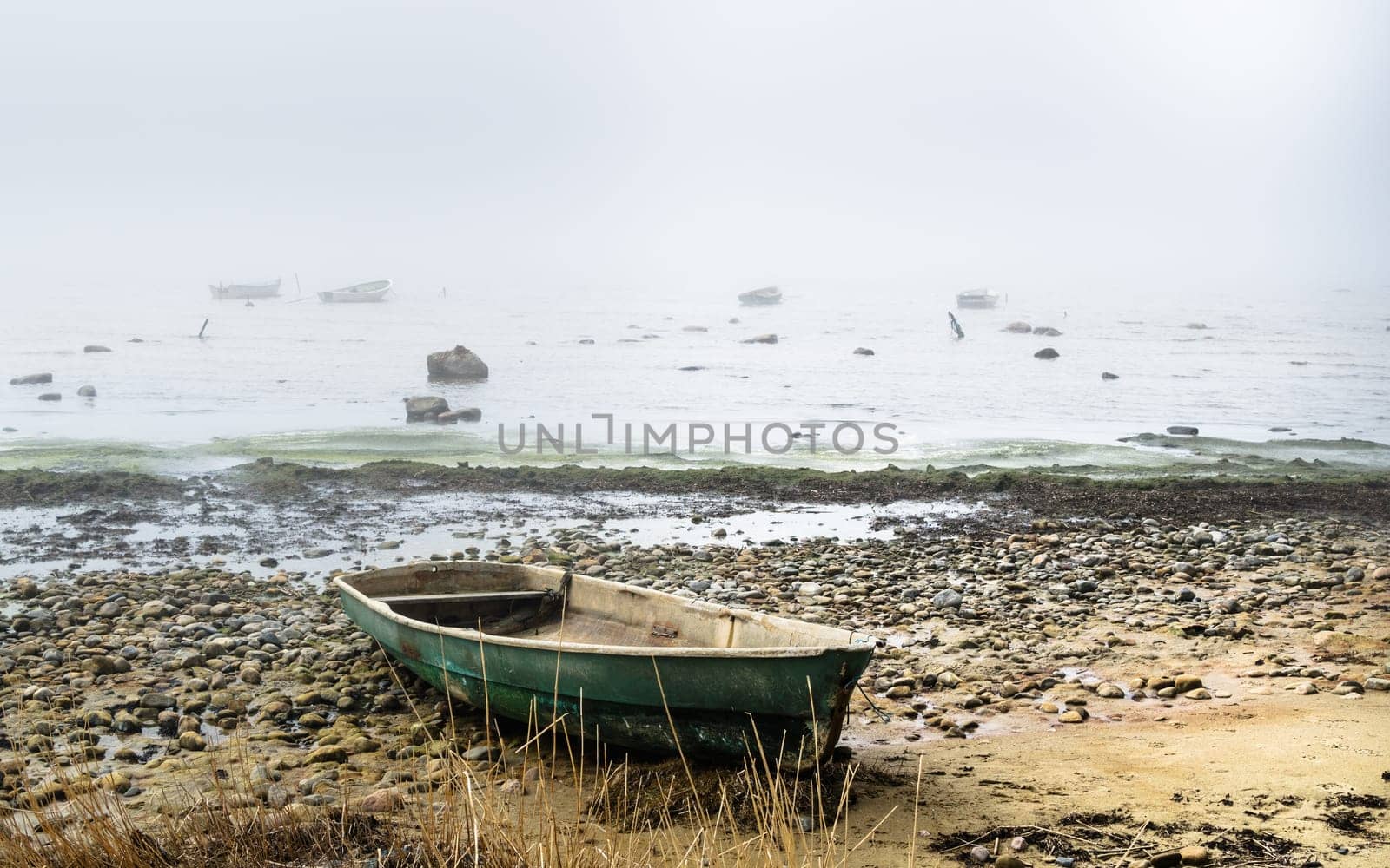 Old fishing boat at coast foggy in the morning