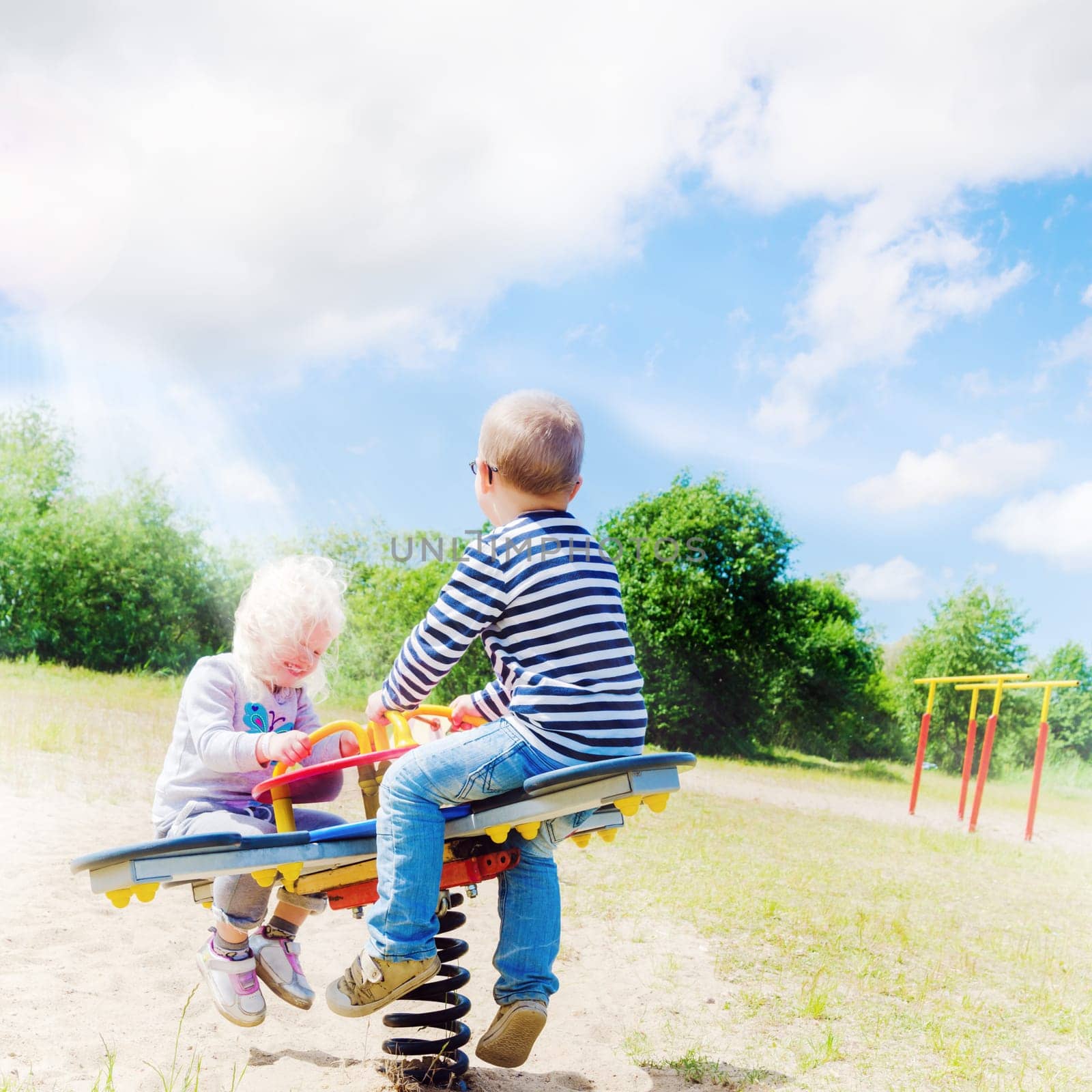 Boy and girl swinging on a swing