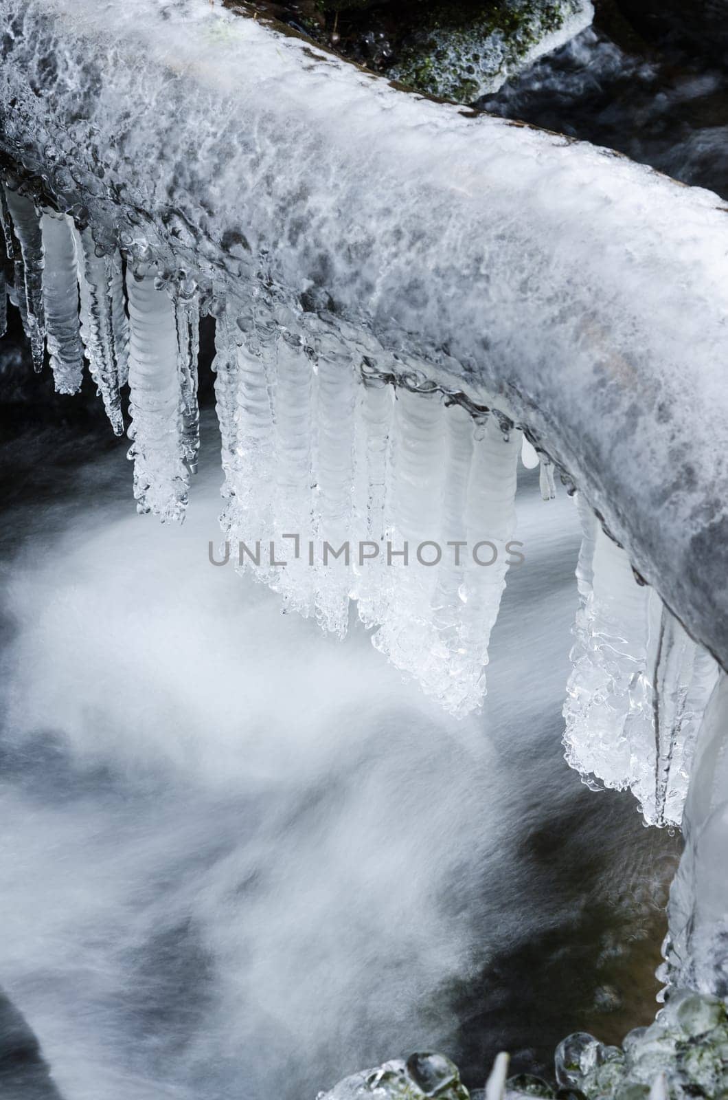 Frozen icicles on water flow,  close-up