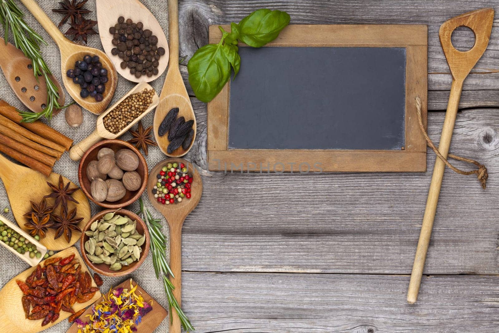 Herbs and spices with cooking spoon and table