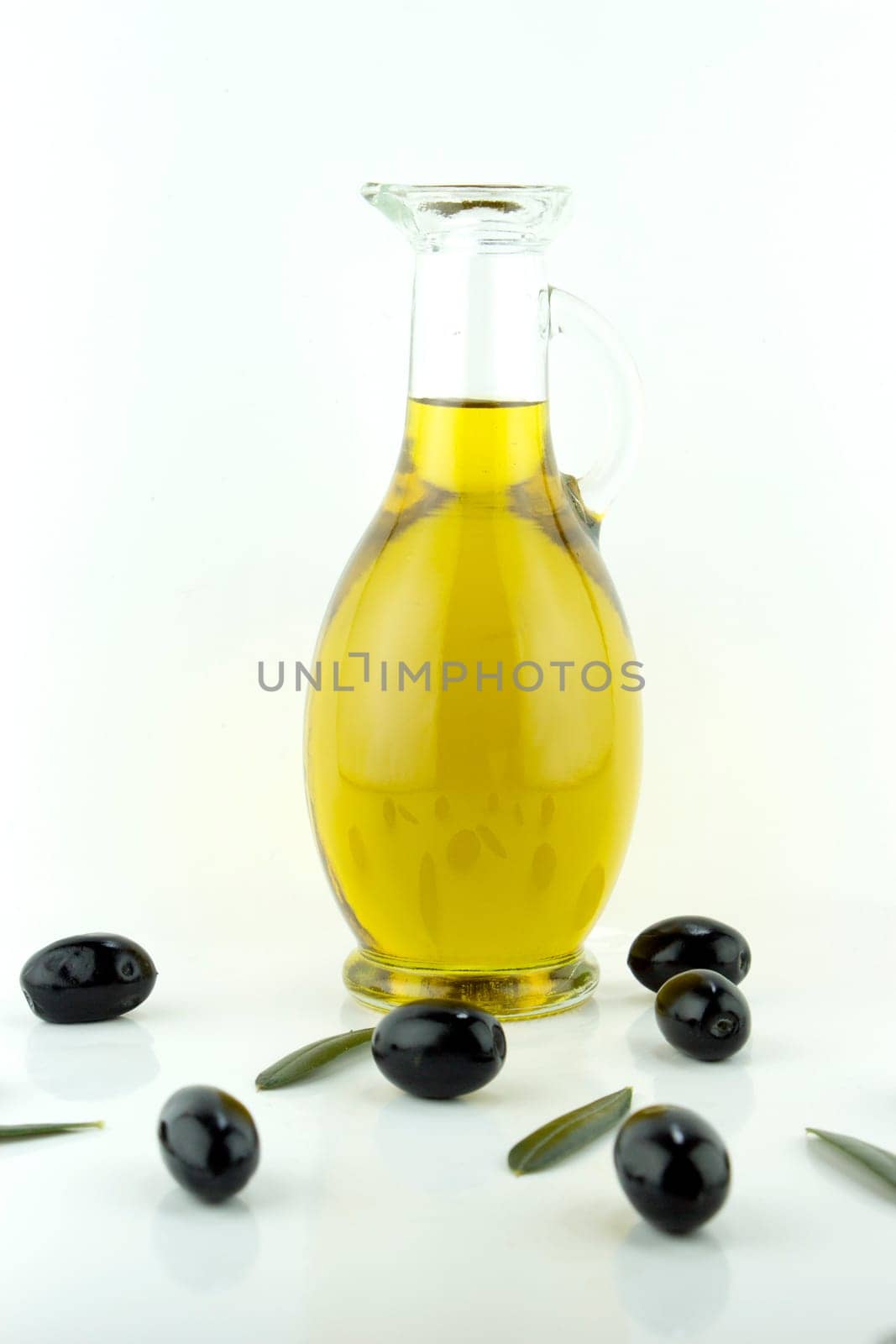 olives and a bottle of olive oil with olive leaves.