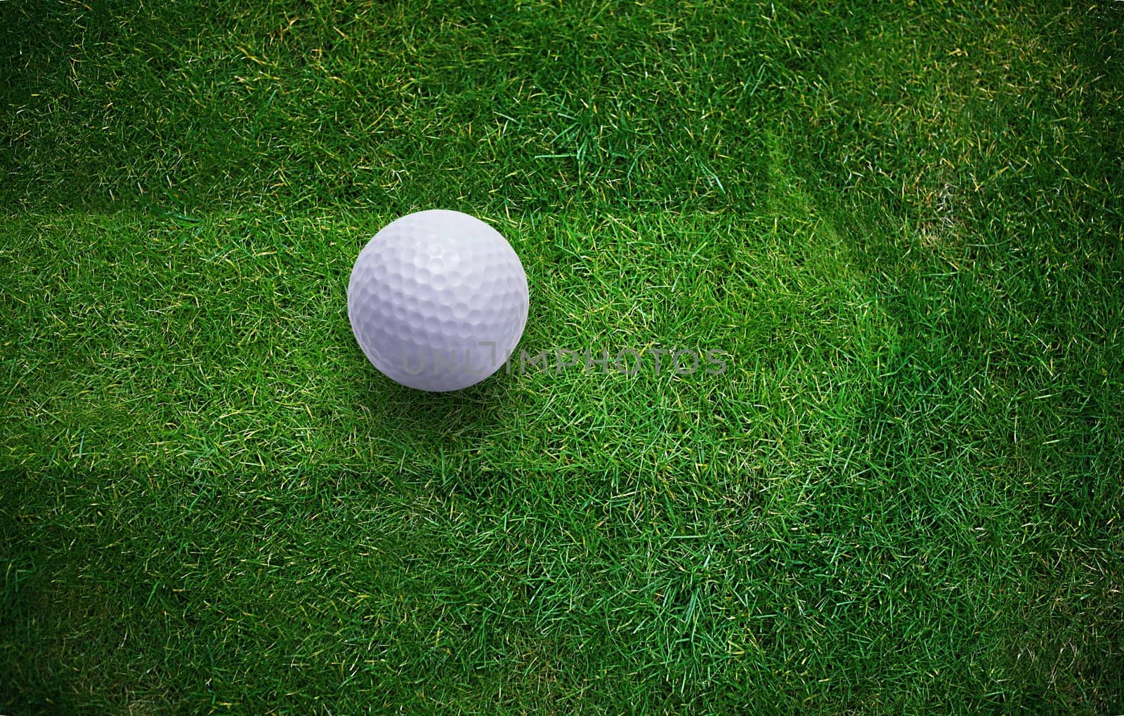 Golf ball on green grass .