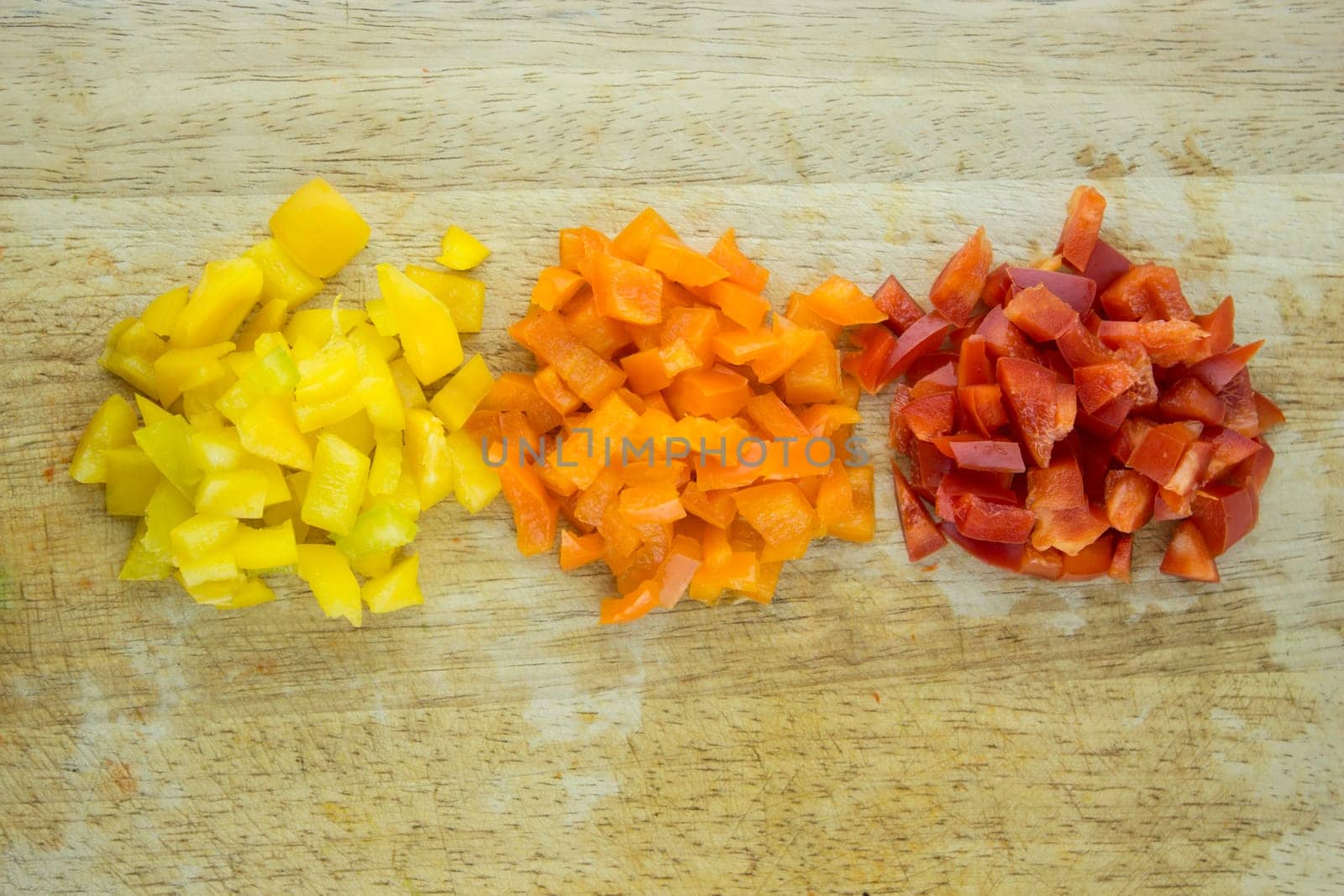 slices of colorful sweet bell pepper on wood board.