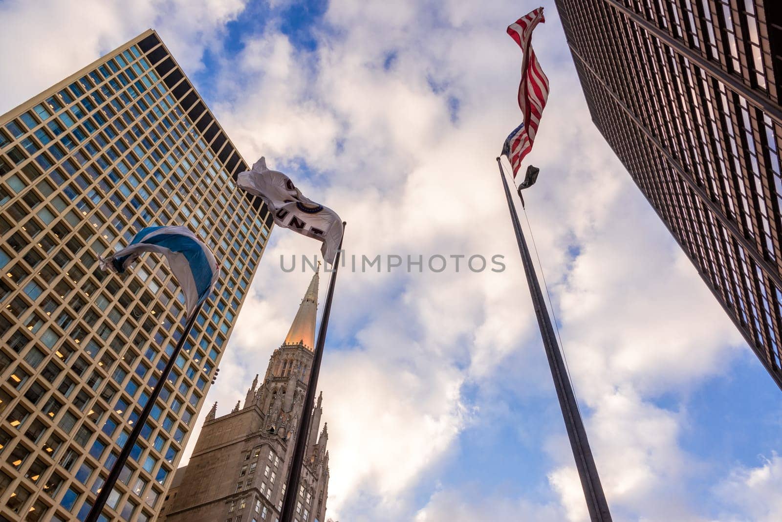 Looking up at buildings and flags in downtown Chicago