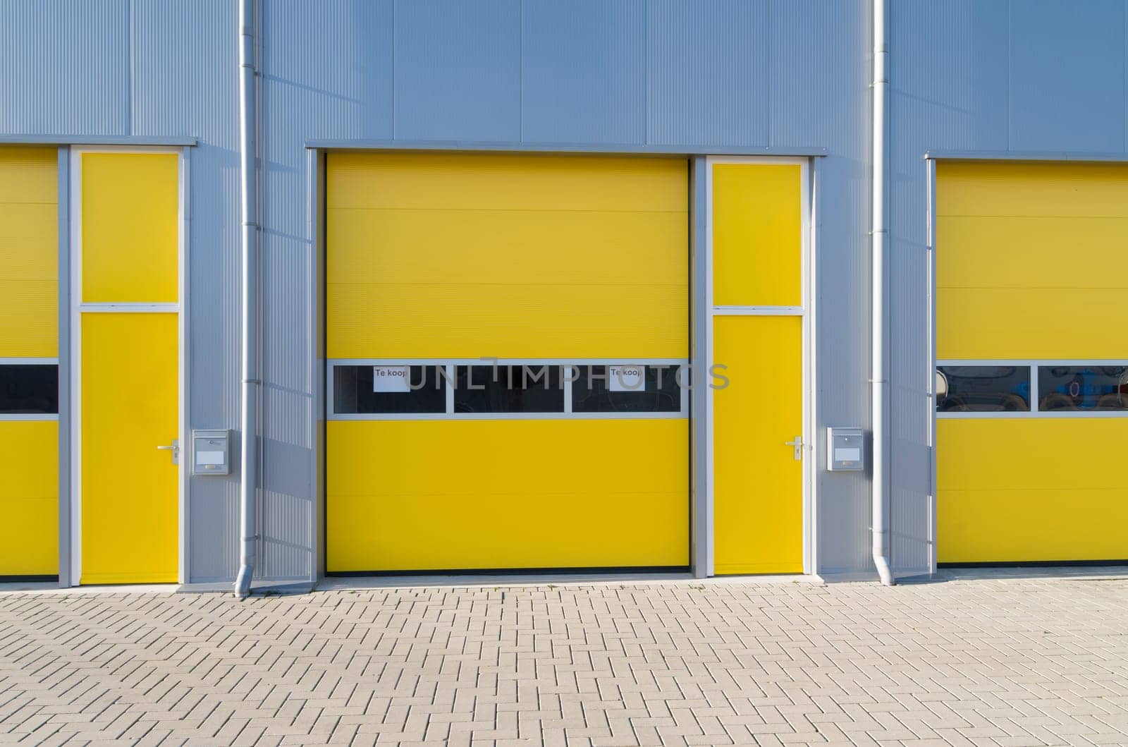 exterior of a commercial warehouse with yellow roller doors