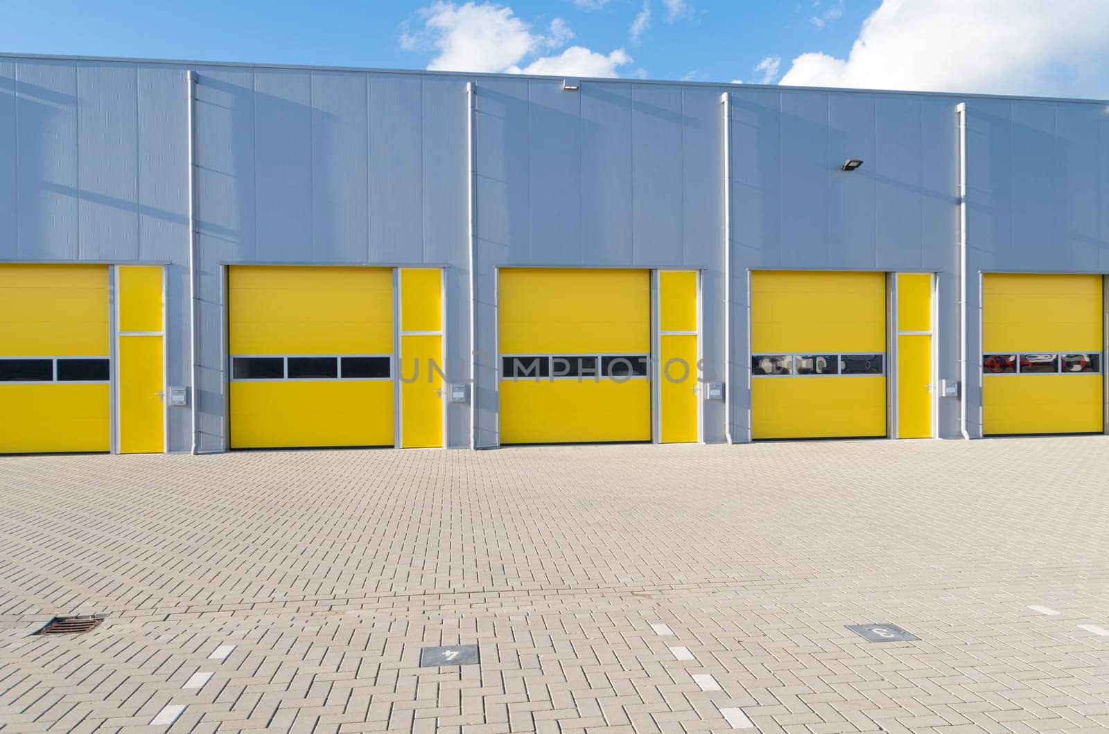 exterior of a commercial warehouse with yellow roller doors