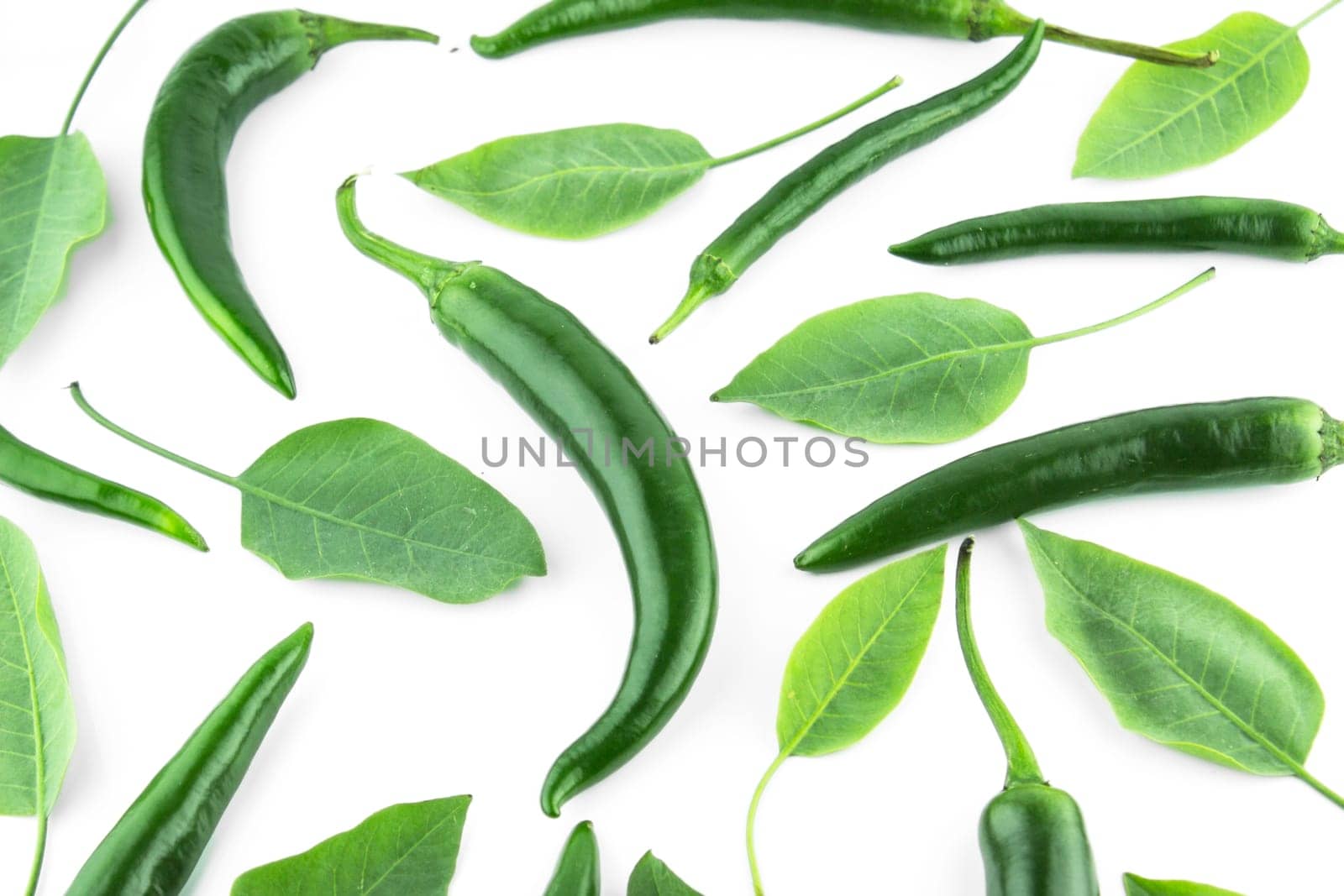 green hot chili pepper with leaves on a white background