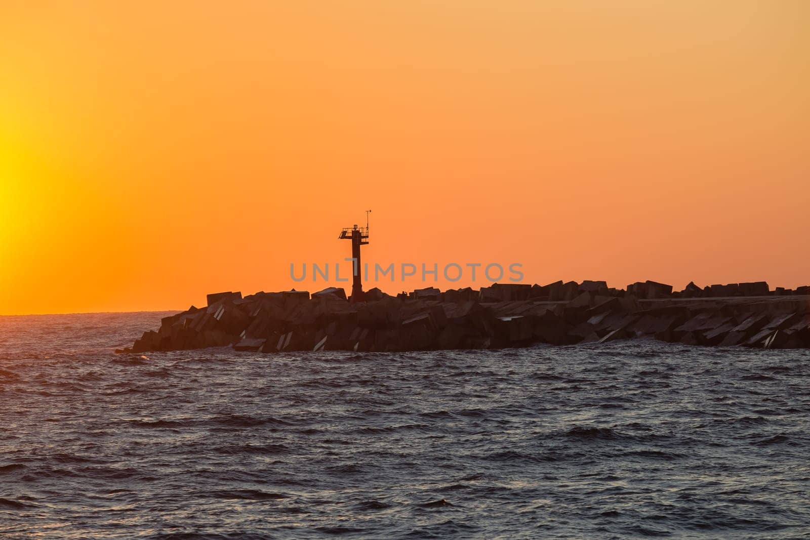 Morning dawn on the harbor pier beacon lights at the entrance into the open ocean seas