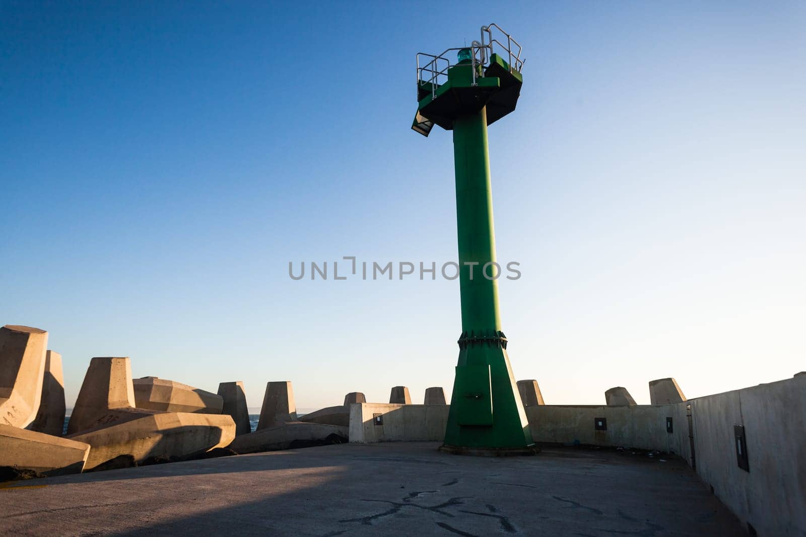 Morning dawn on the harbor pier beacon lights at the entrance into the open ocean seas