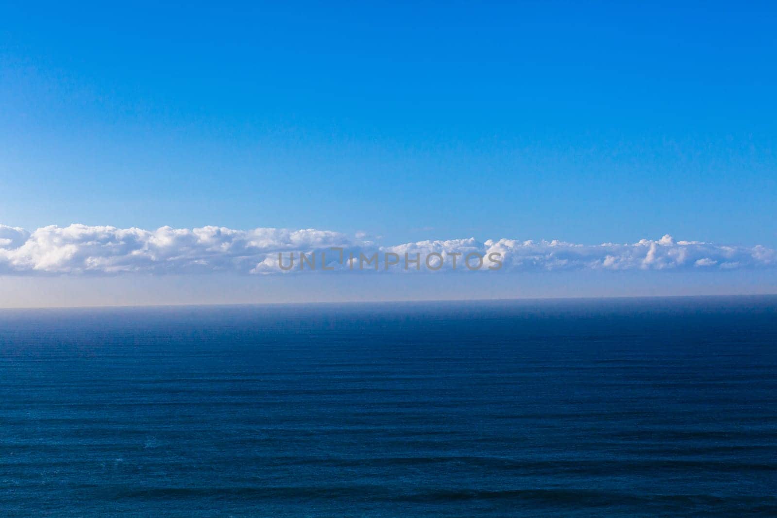 Overlooking birds eye view of blue ocean sea swells and clouds on horizon