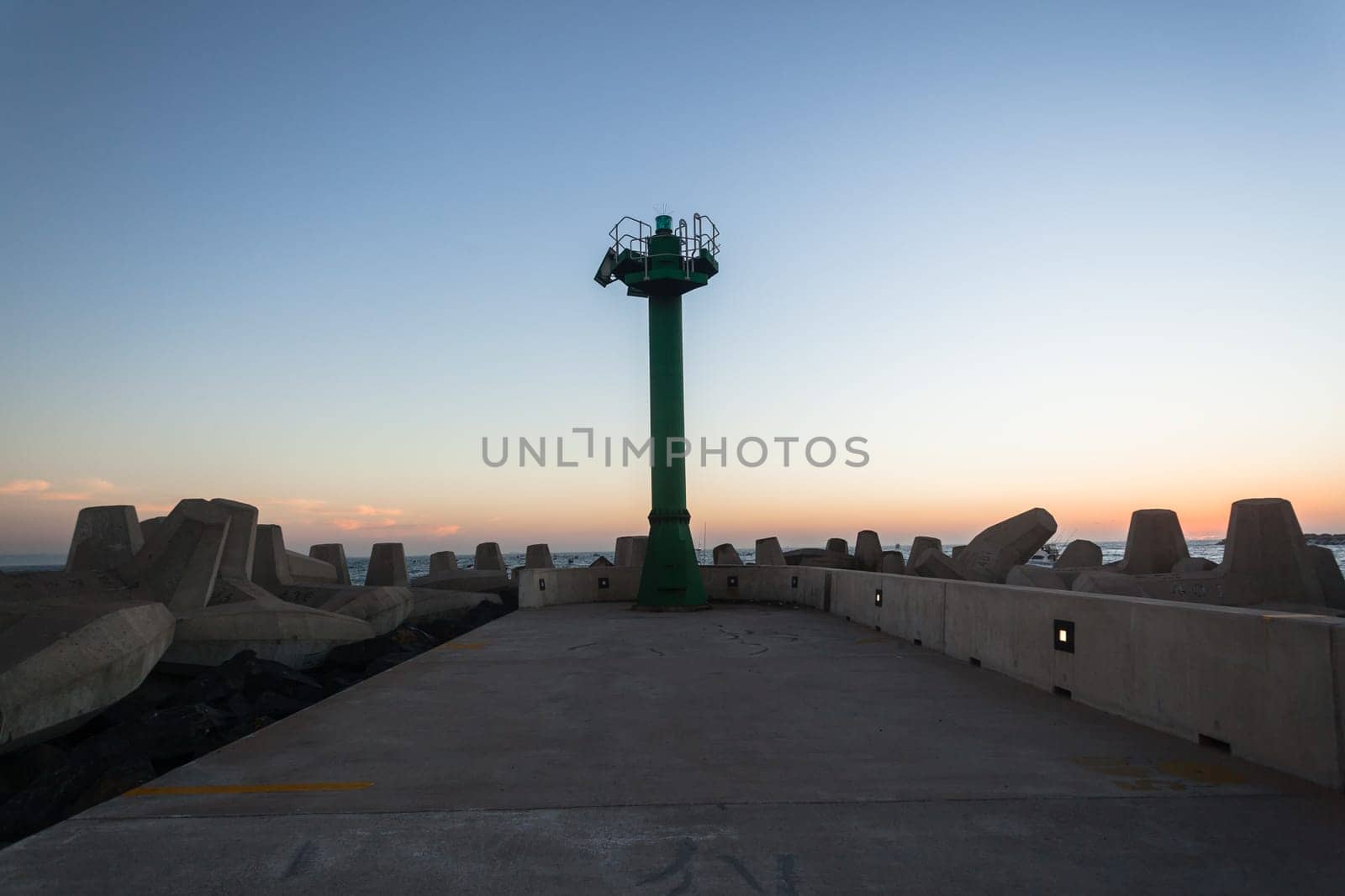 Morning dawn on the harbor pier beacon lights at the entrance into the open ocean seas
