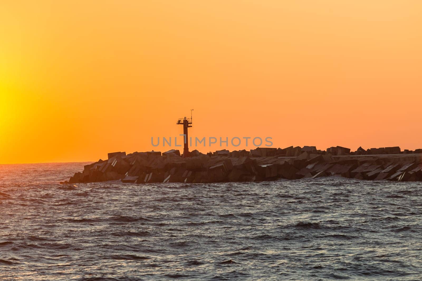 Morning dawn on the harbor pier beacon lights at the entrance into the open ocean seas