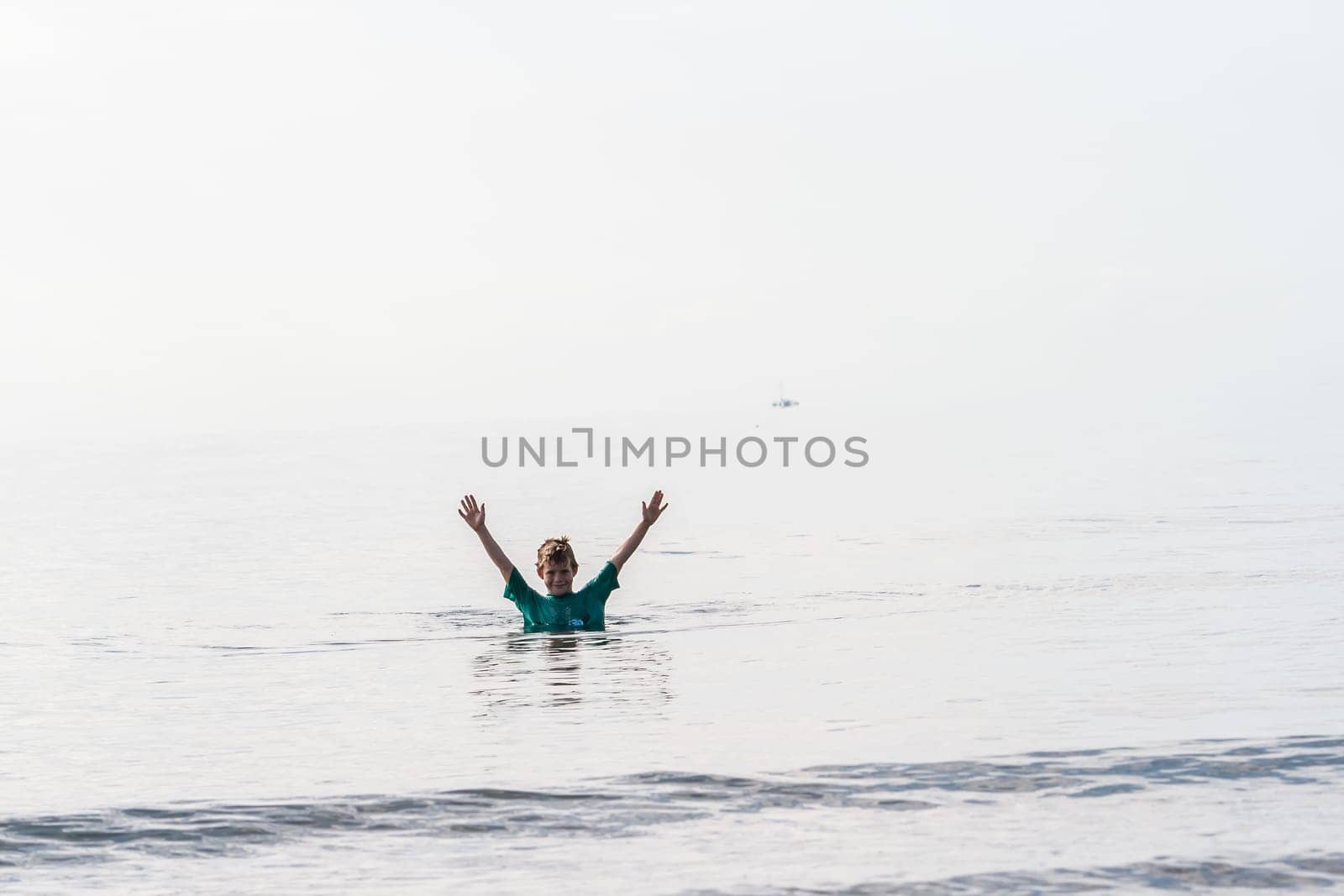 Boy in waters walking along tropical waters at  mission beach nearby Cairns Queensland Australia