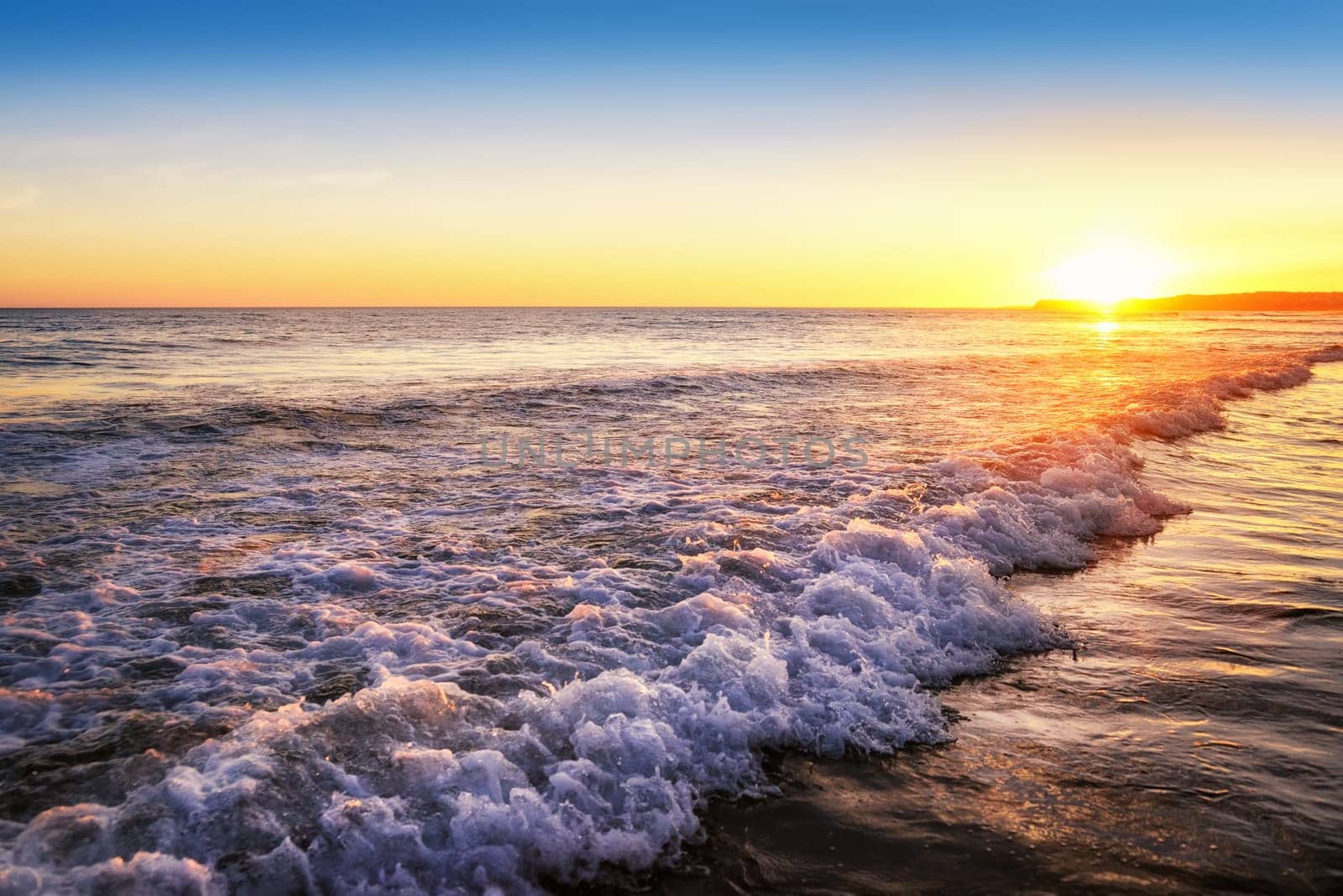 Sunset with emotional colors by the sea,with wave and sand