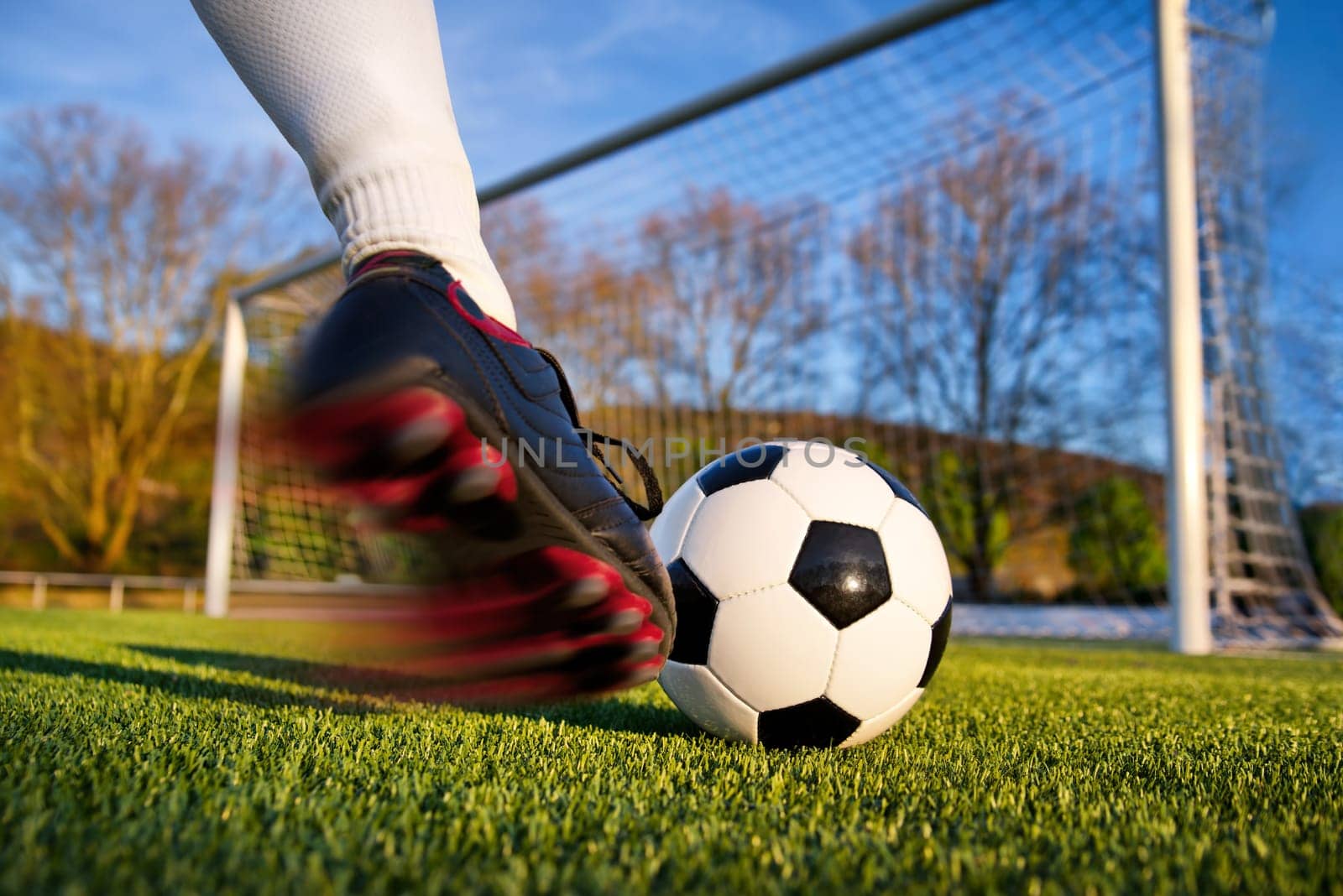 Footballer kicks the ball towards goal,natural background