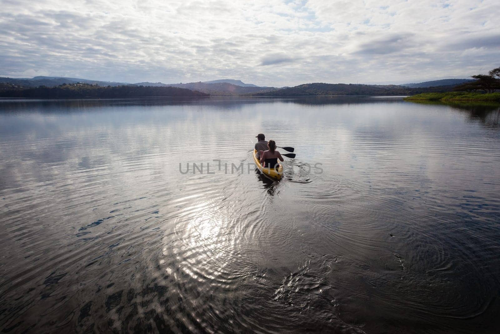 Girl boy paddle out on dam smooth waters to bass fish
