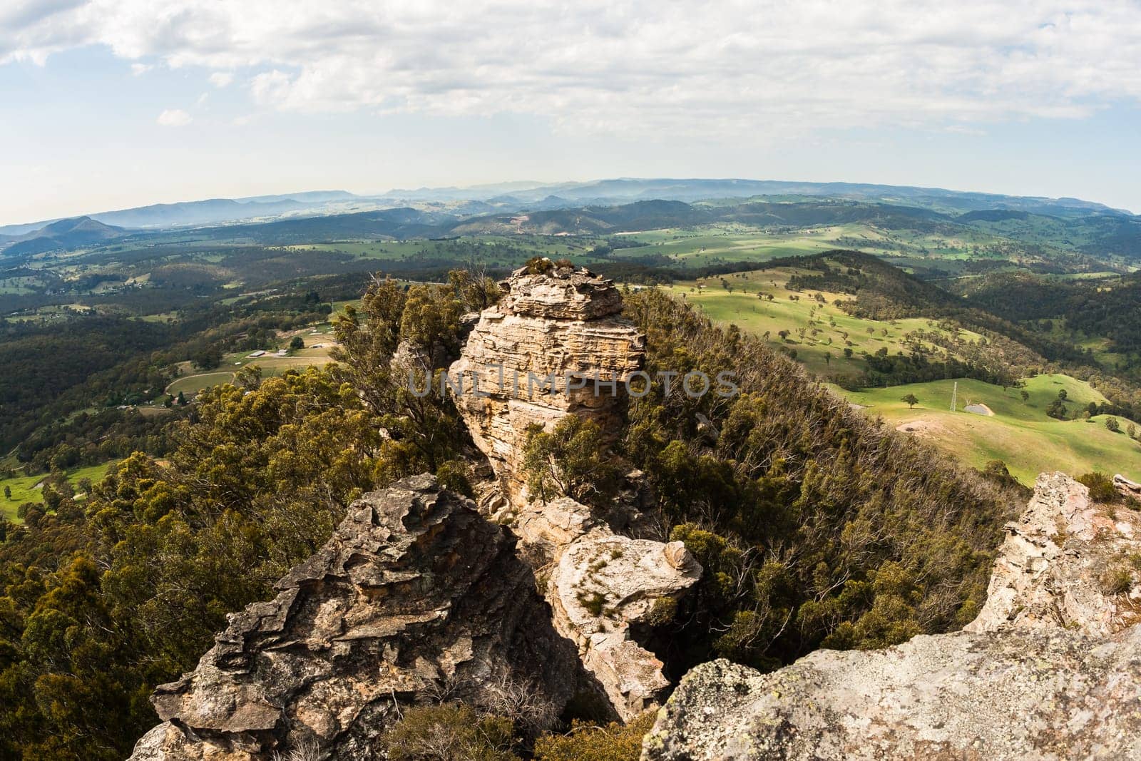 Scenic birds eye view overlooking view from mountain ridge over green farmlands vegetation landscape
