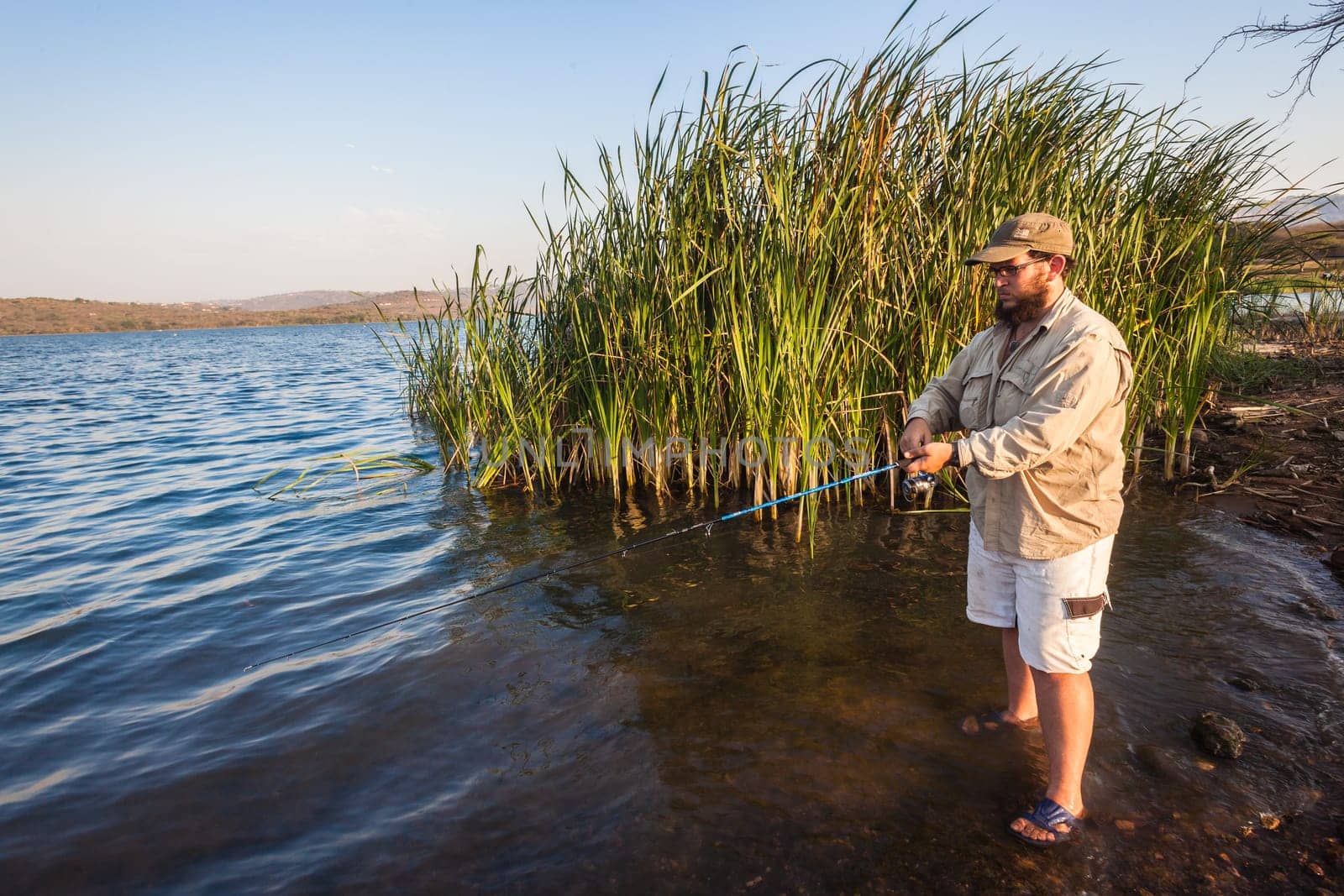 Bass fisherman afternoon by dam waters