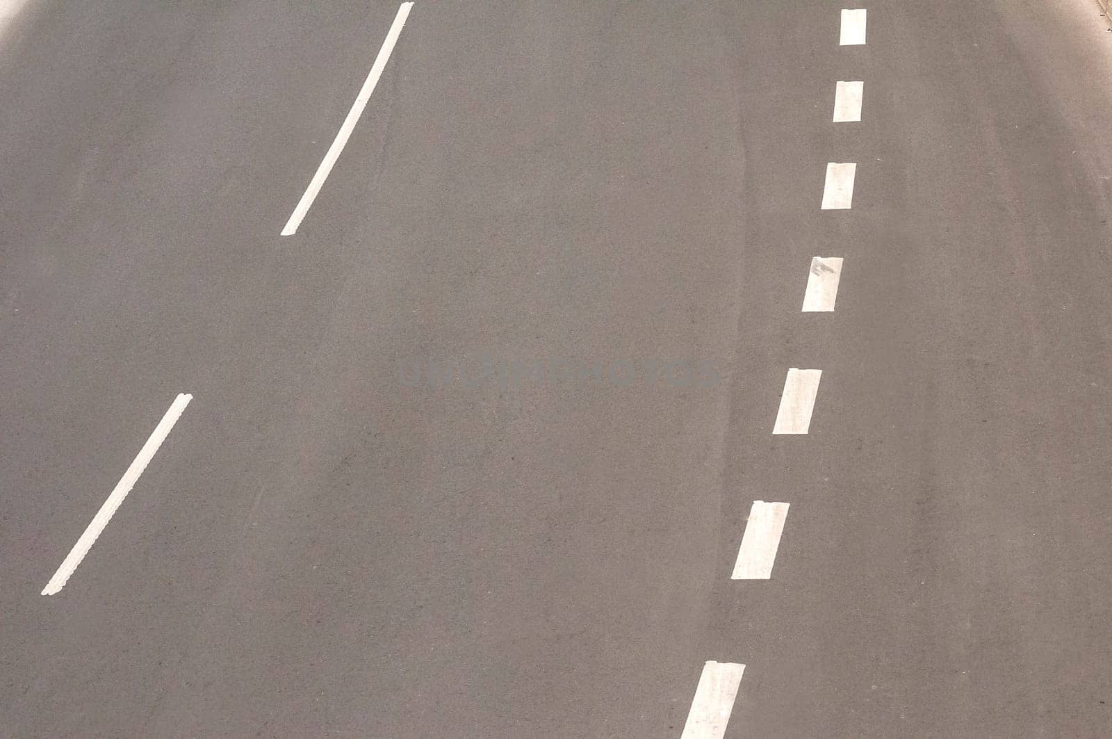 Part of used asphalt roadway with road marking lines