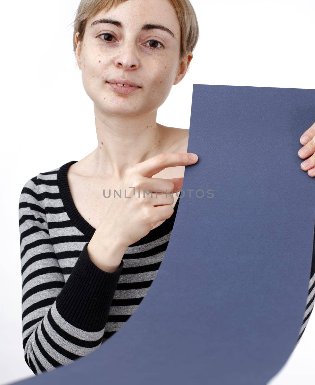 Young blonde woman holding a blank piece of paper.