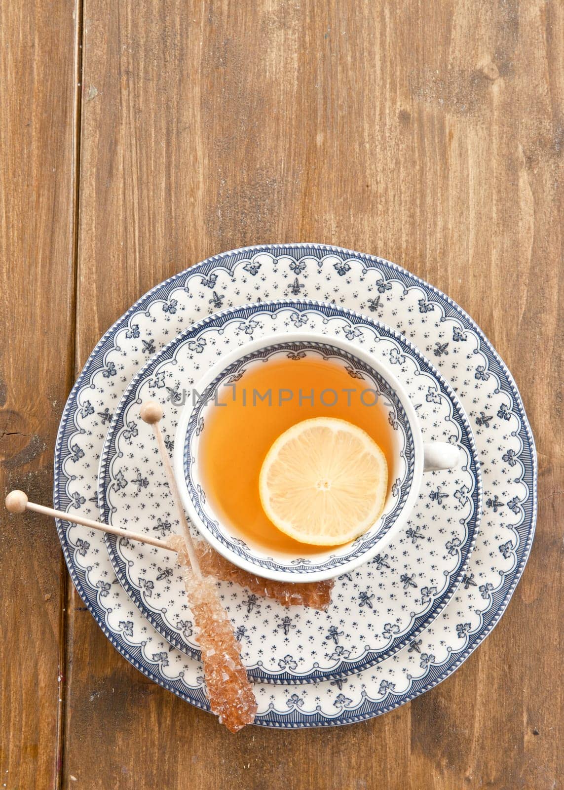 A cup of tea with lemon on rustic wooden background