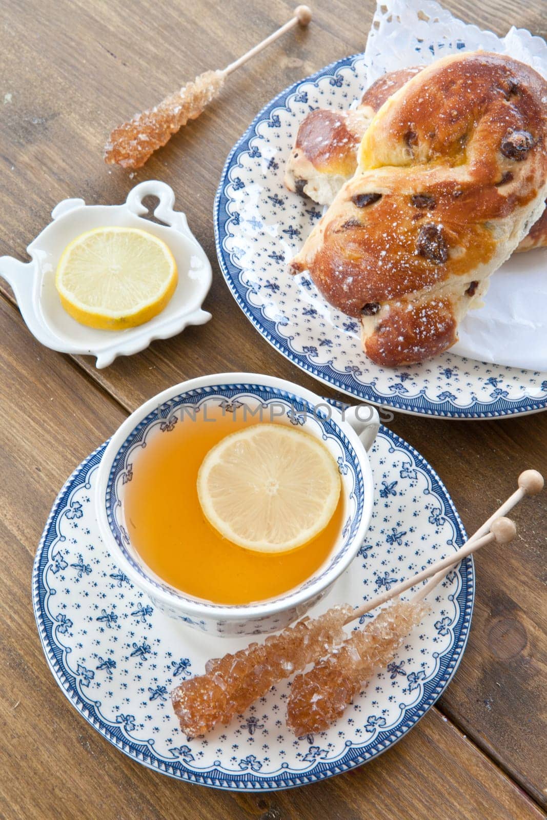 A cup of tea with lemon on rustic wooden background