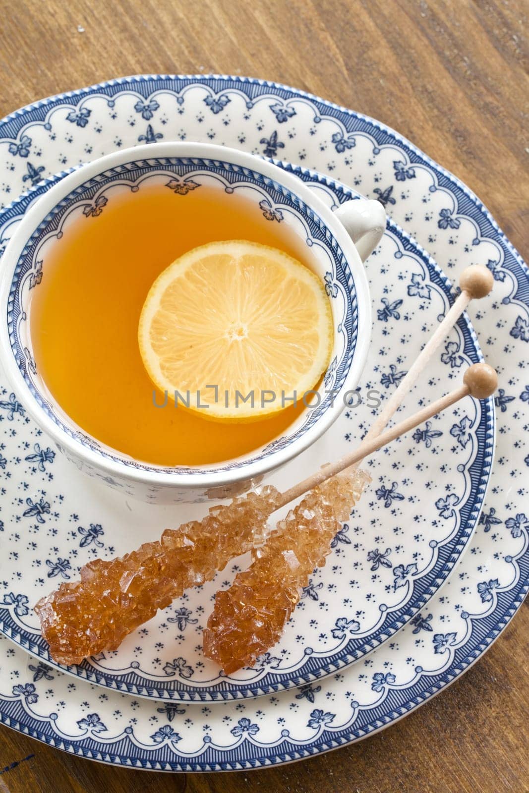 A cup of tea with lemon on rustic wooden background