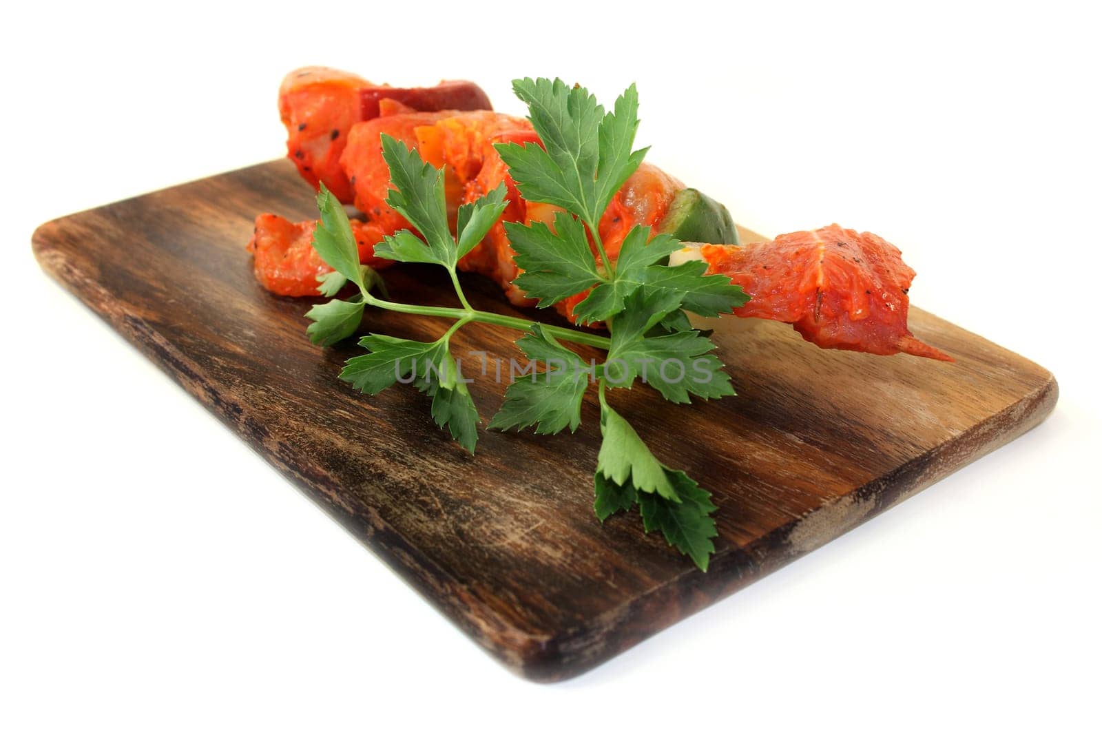 raw,marinated meat skewer against a white background