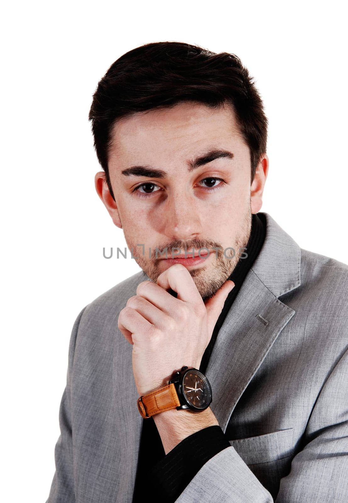 A handsome businessman standing for isolated white background in a .suit with his hand on his chin..
