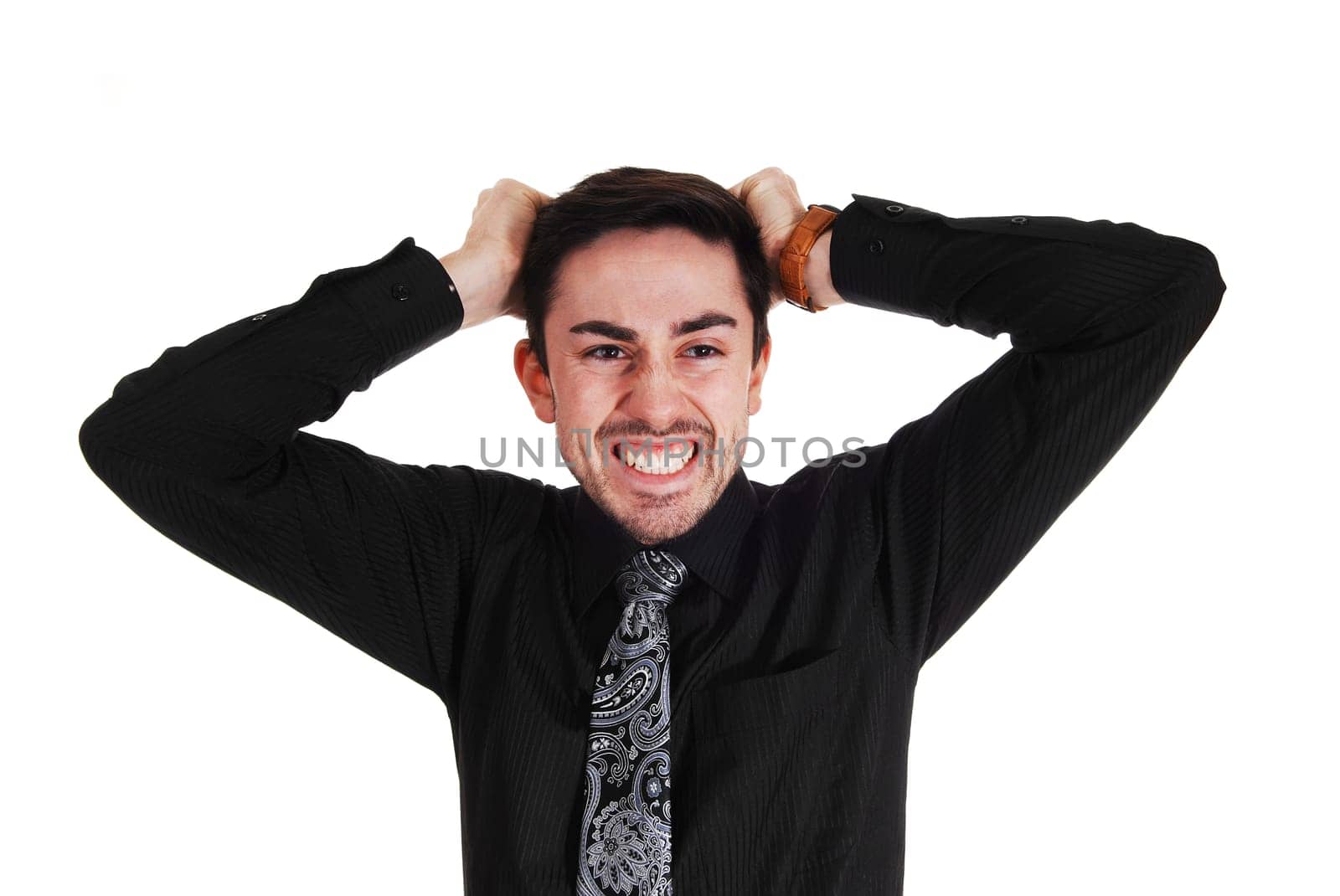 A very angry young man messing his hair standing isolated for white.background..