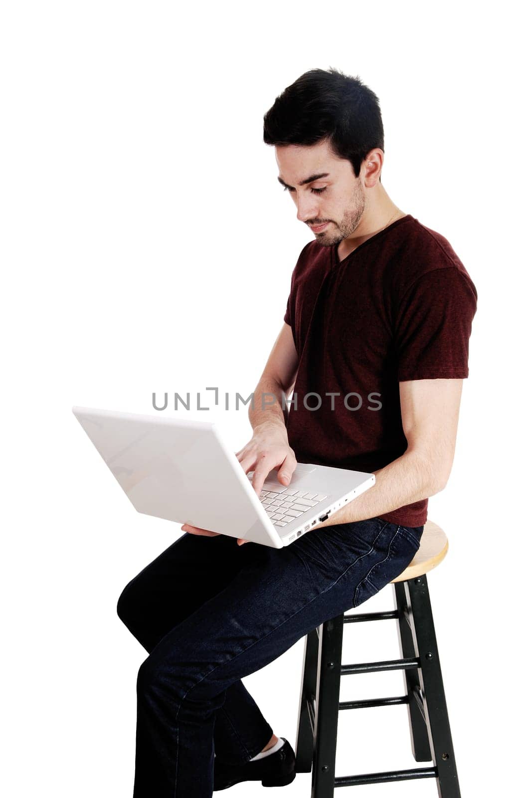 A young man sitting on a chair with his laptop on his lap, isolated on.white background..