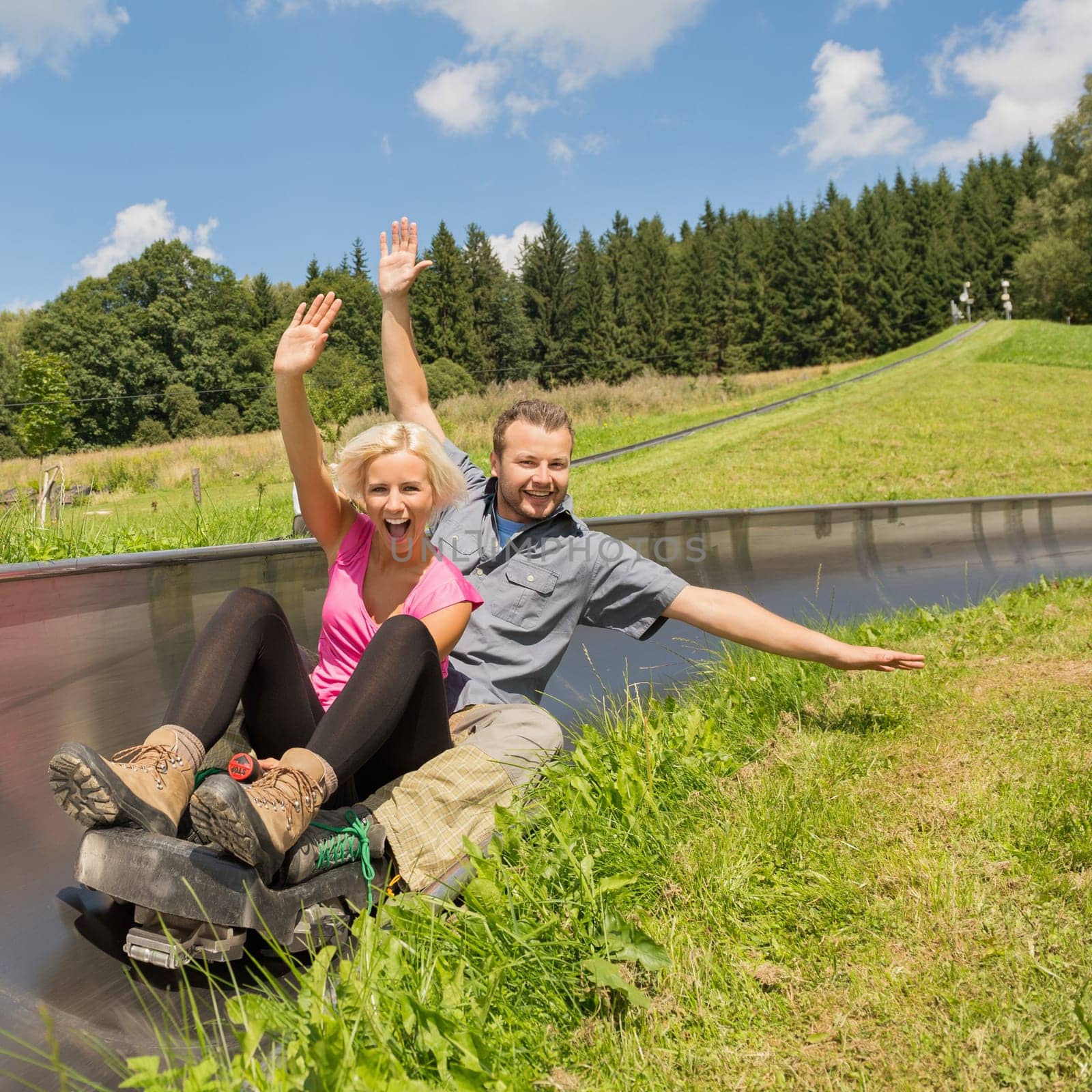 Portrait of young couple enjoying summer sledge ride