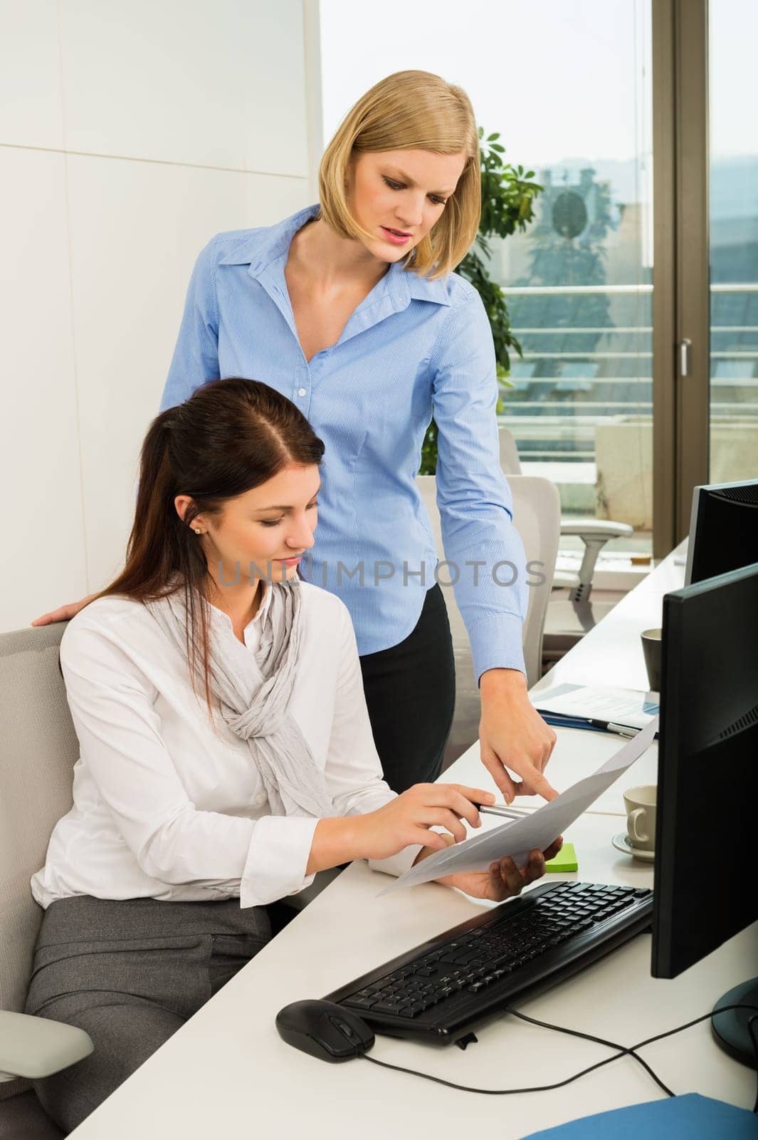 Young businesswomen discussing at office desk