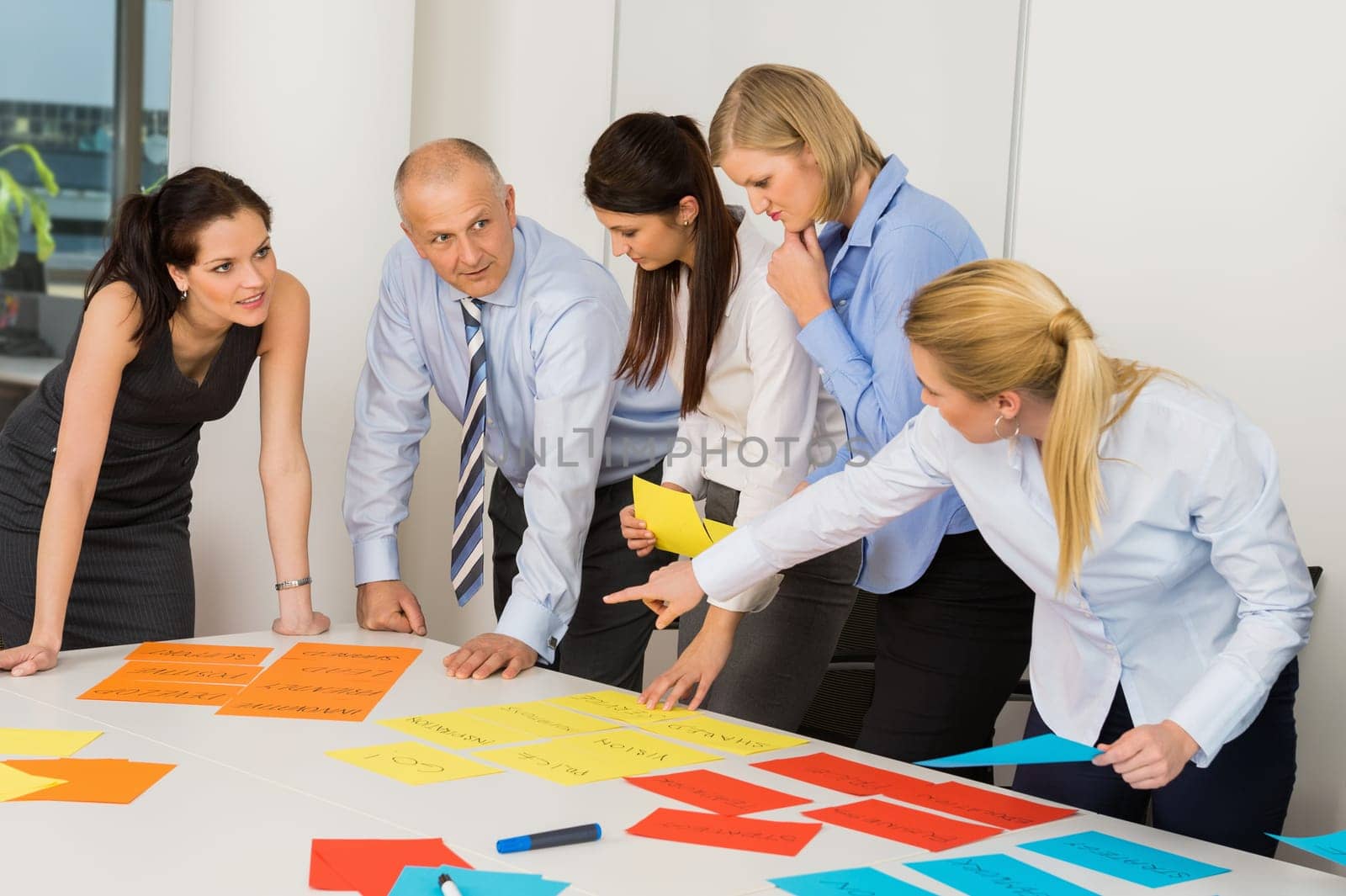 Business team discussing multicolored labels in boardroom meeting