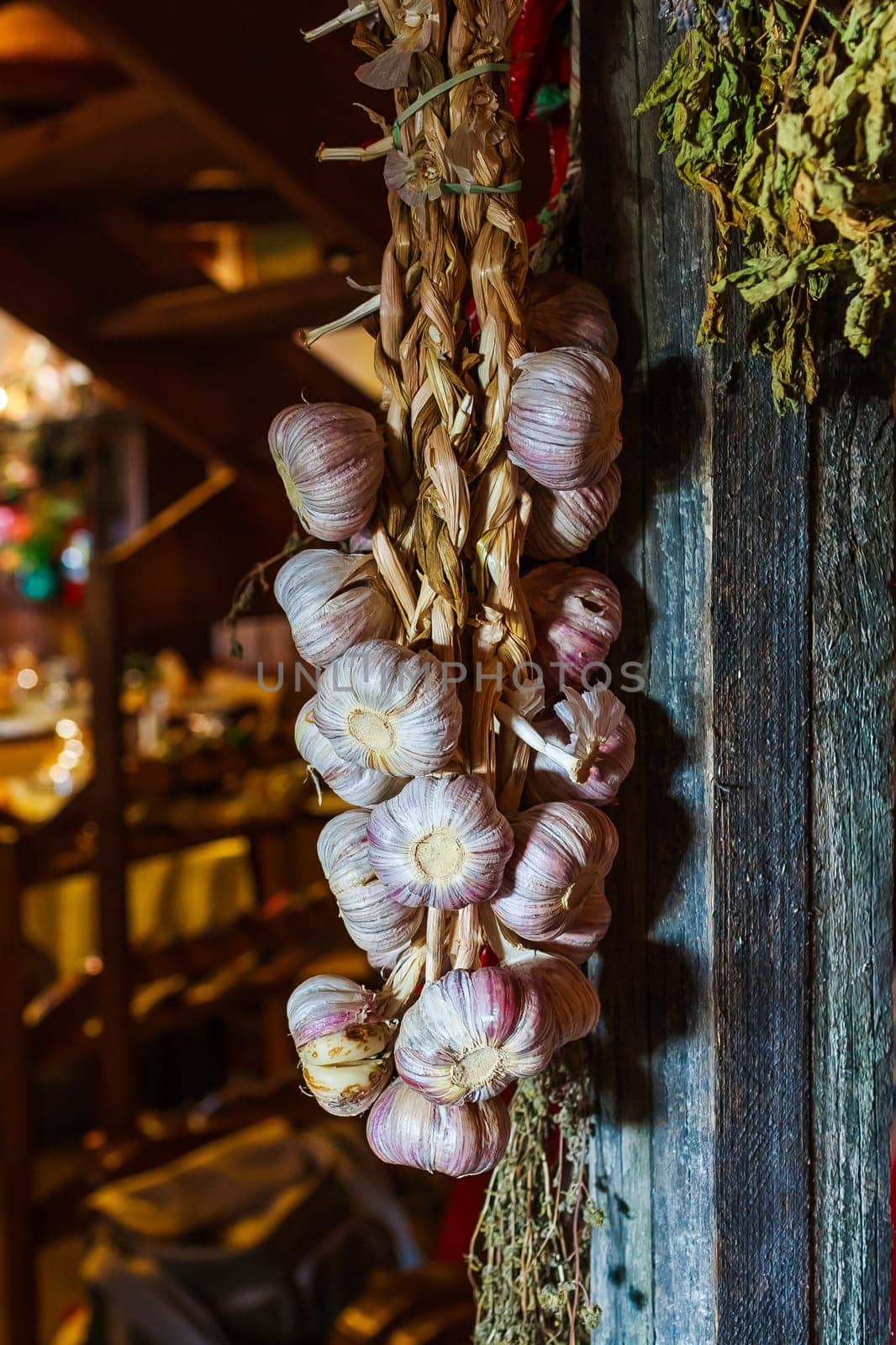 garlic bulbs hanging on wooden beam.