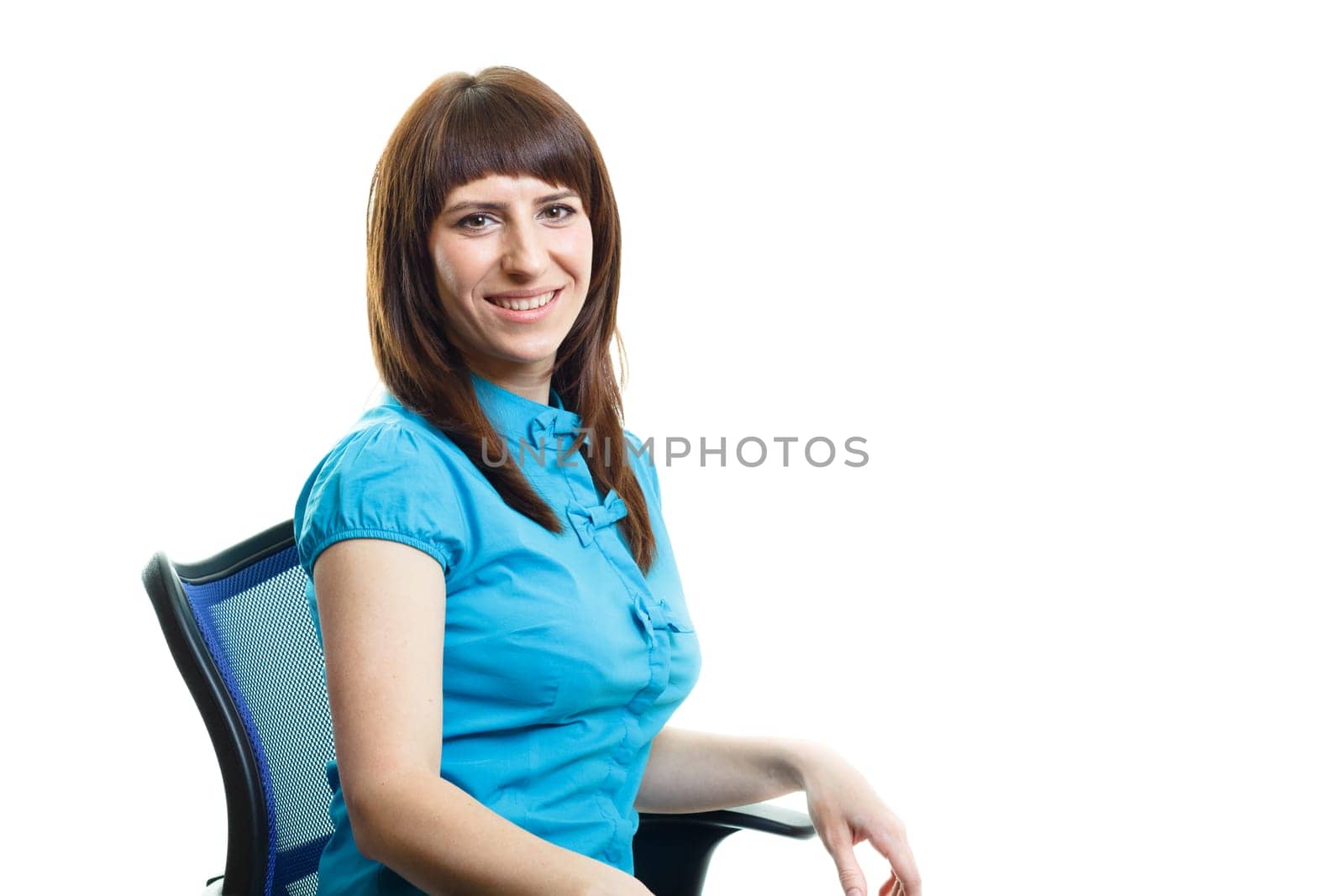 Smiling confident attractive girl sitting on a chair against white background
