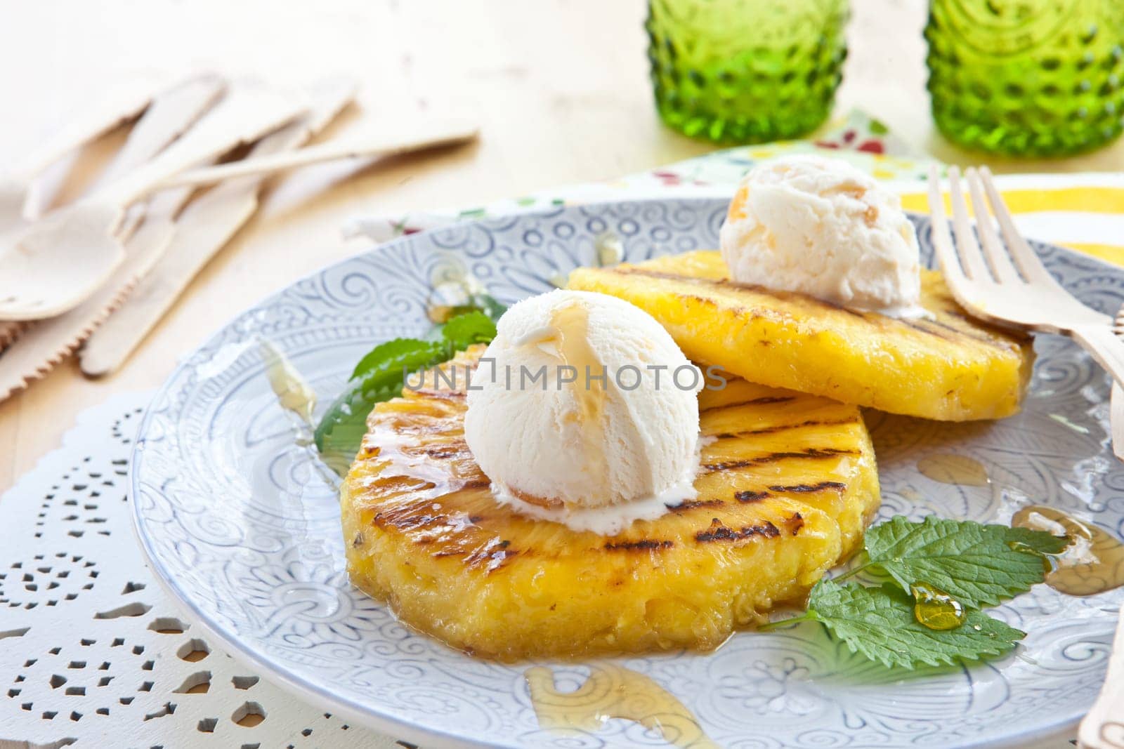 Grilled pineapple rings with ice cream balls and honey