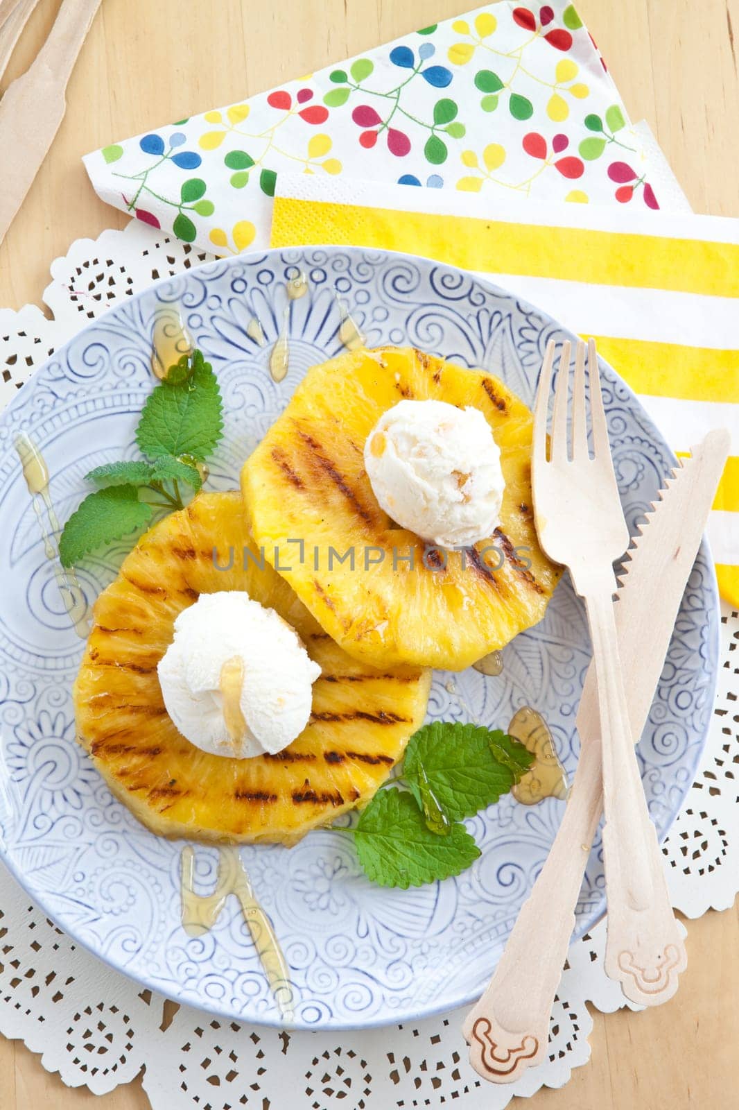 Grilled pineapple rings with ice cream balls and honey