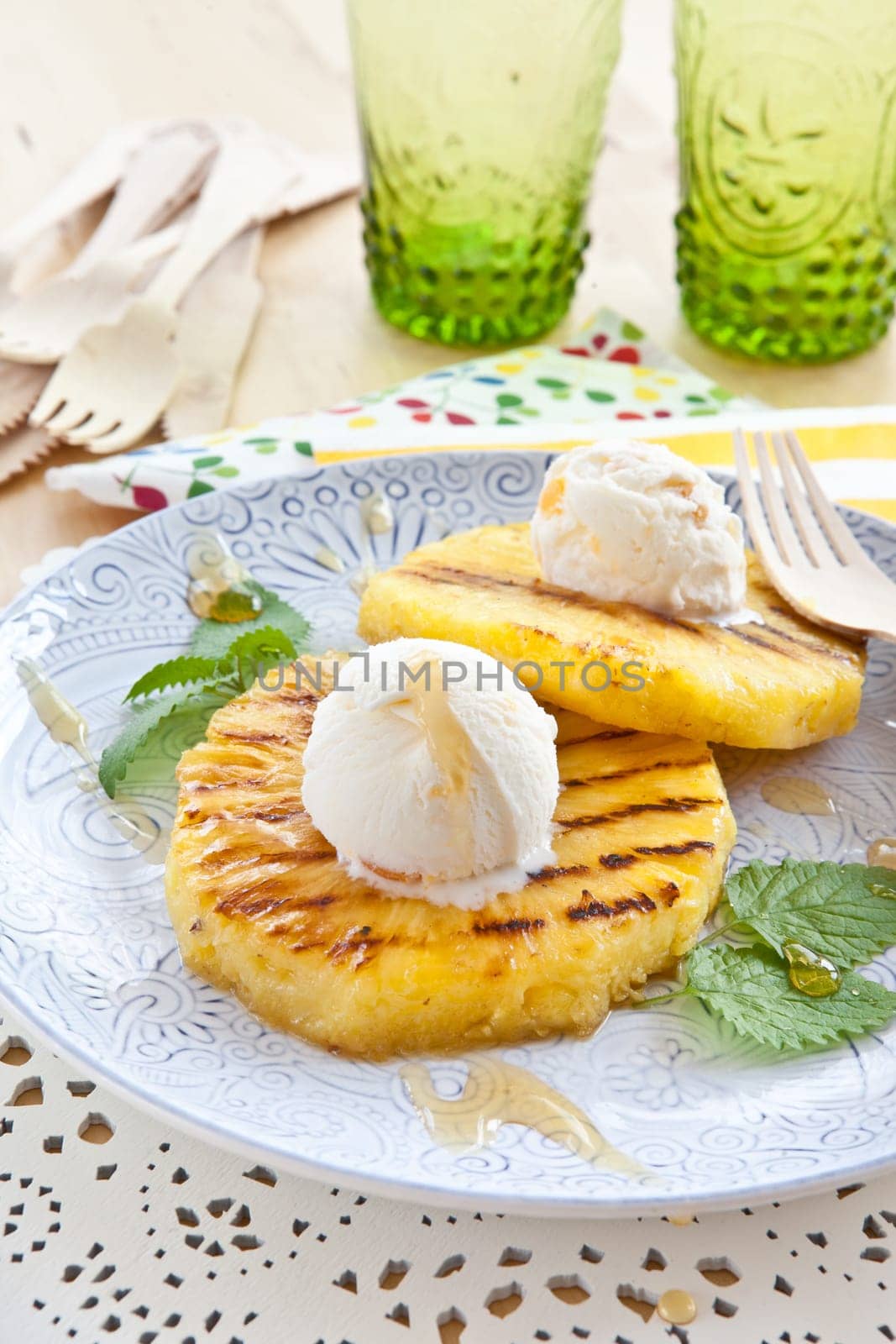 Grilled pineapple rings with ice cream balls and honey