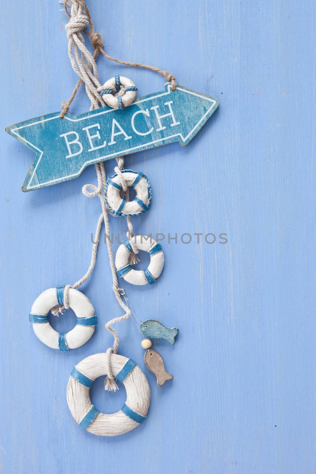 Decorative signpost to the beach on a blue background made of wood