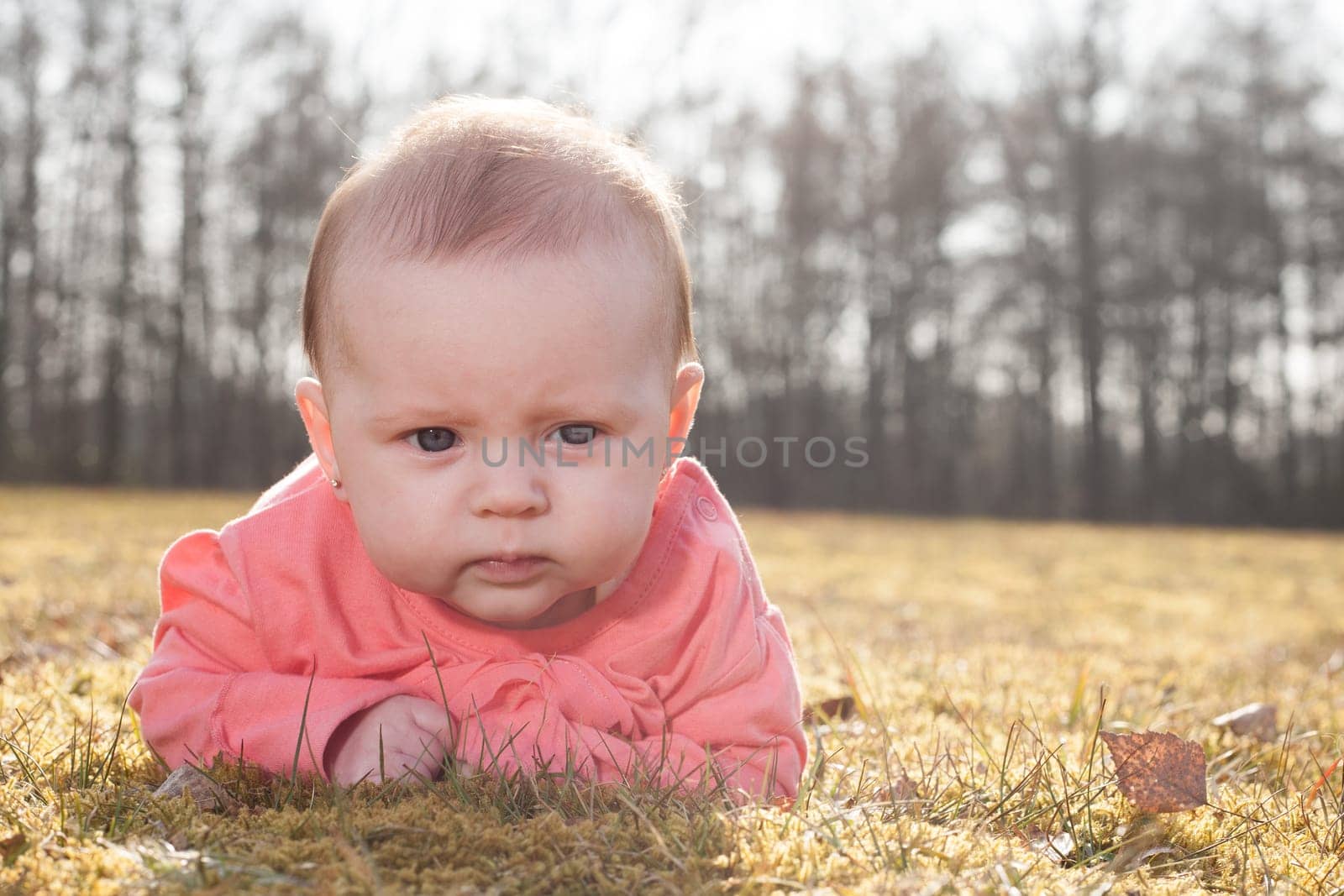 Little baby on the grass in the sun