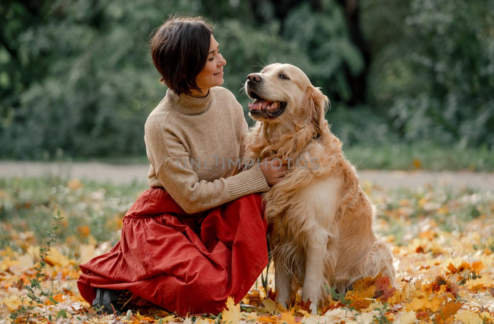 Young woman in autumn park with her dog by tan4ikk1