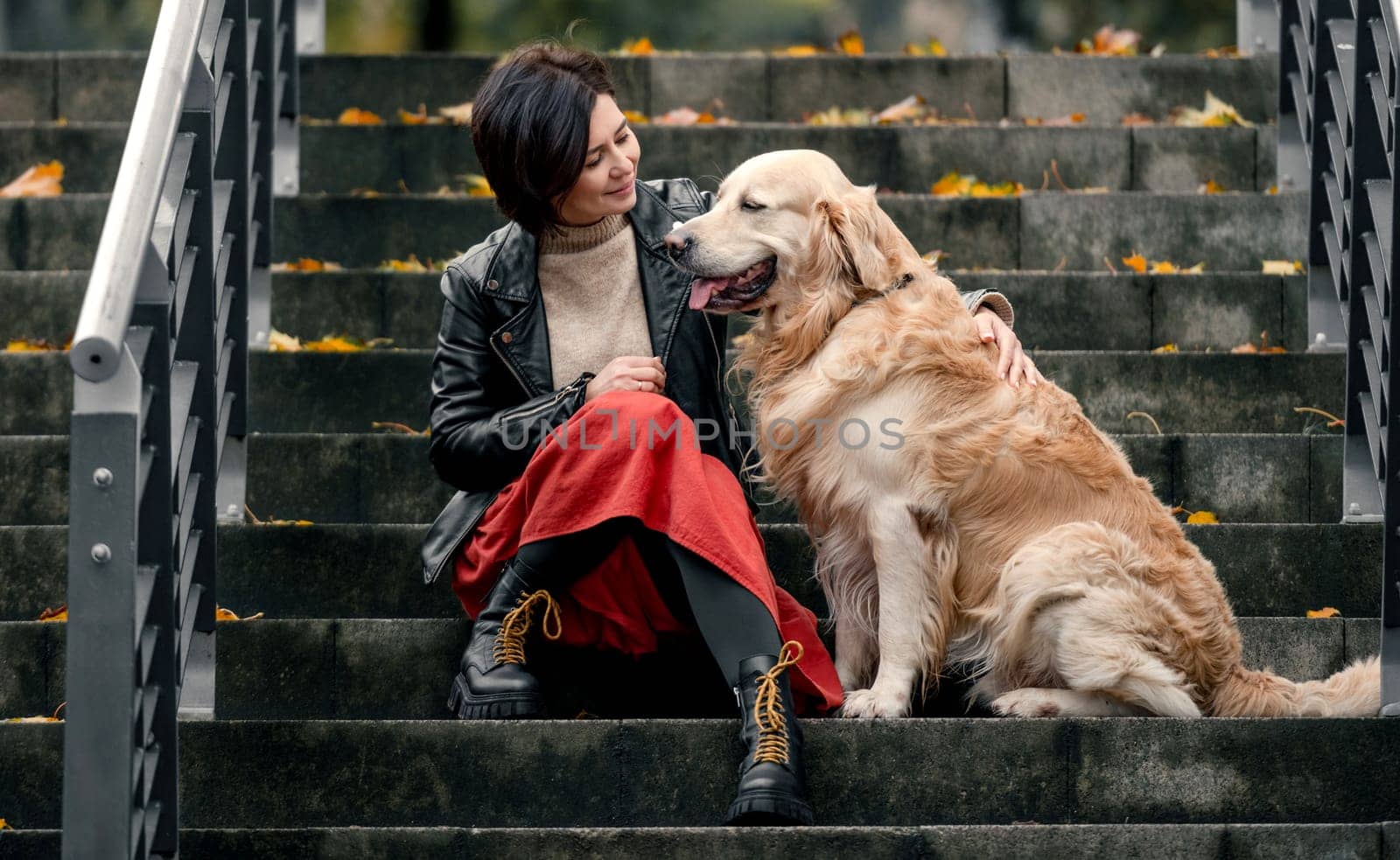 Young woman sitting on a ladder with a Golden Retriever dog by tan4ikk1