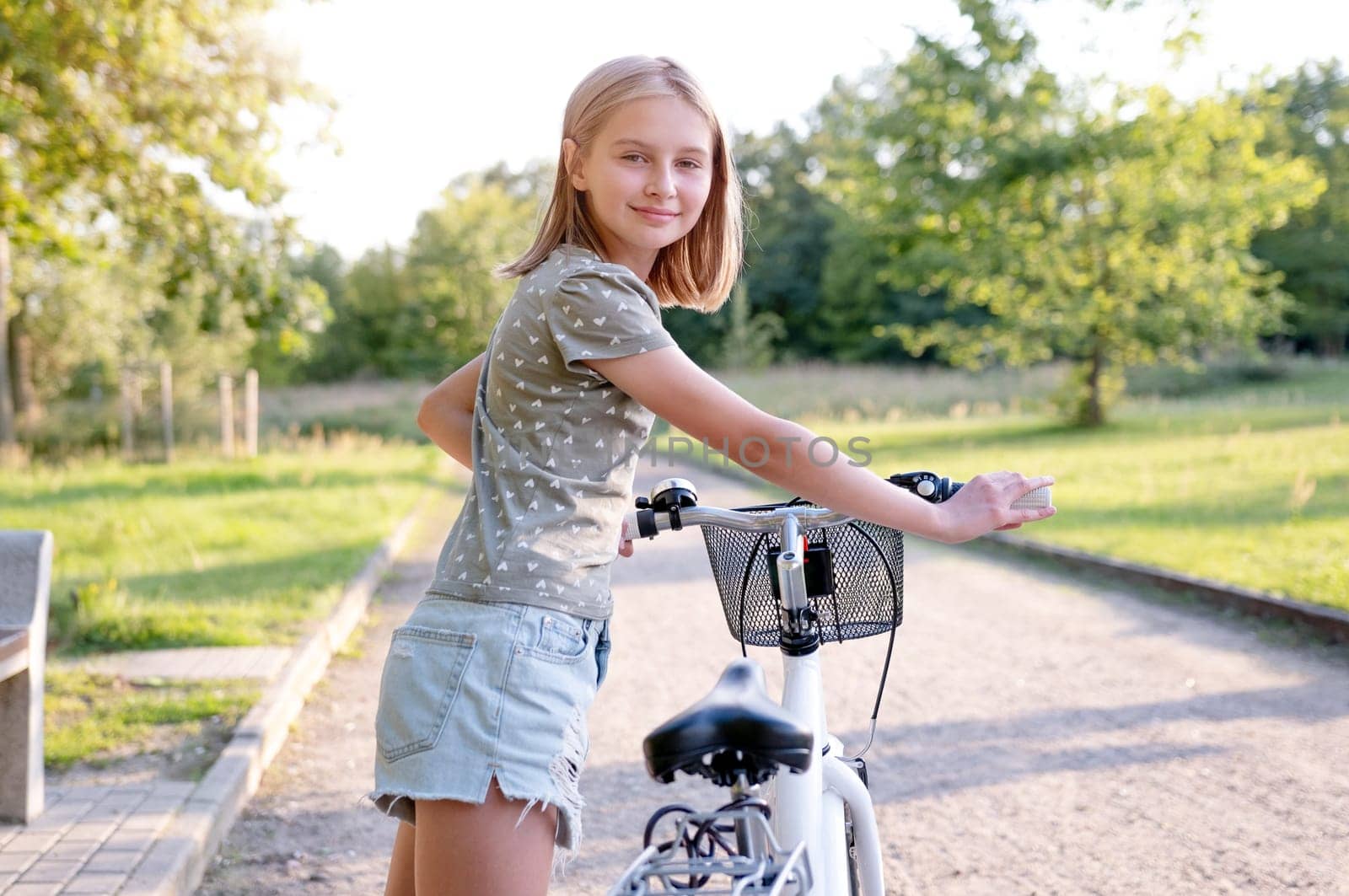 Cute preteen girl with bycicle outdoors by tan4ikk1