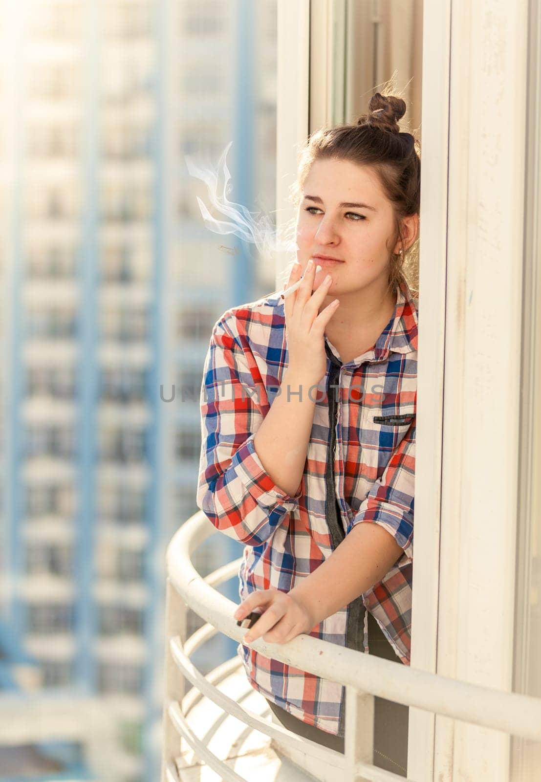 Toned portrait of beautiful woman smoking cigarette on balcony