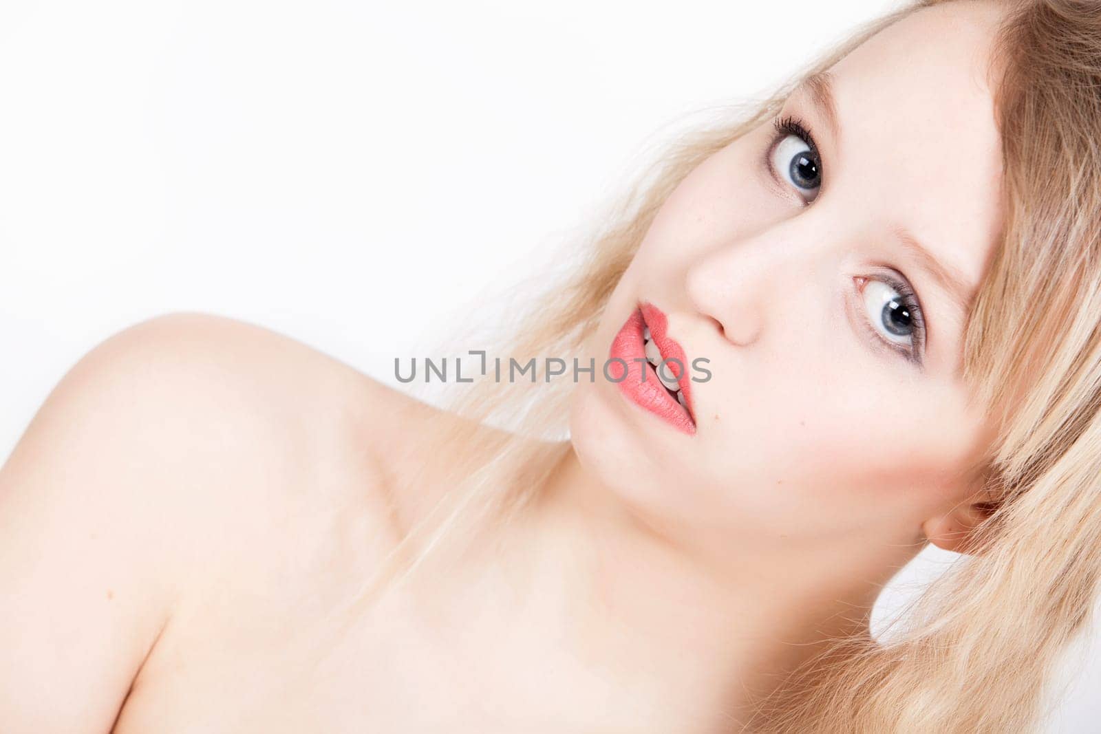 Portrait from young blond woman on a white background with much skin visible