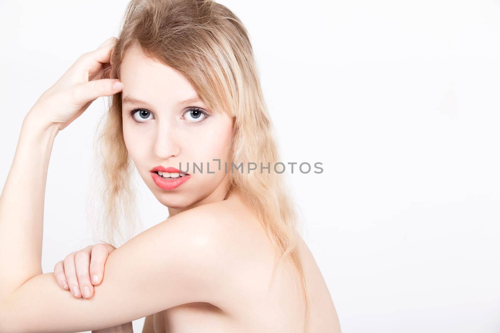 Portrait from young blond woman on a white background with much skin visible