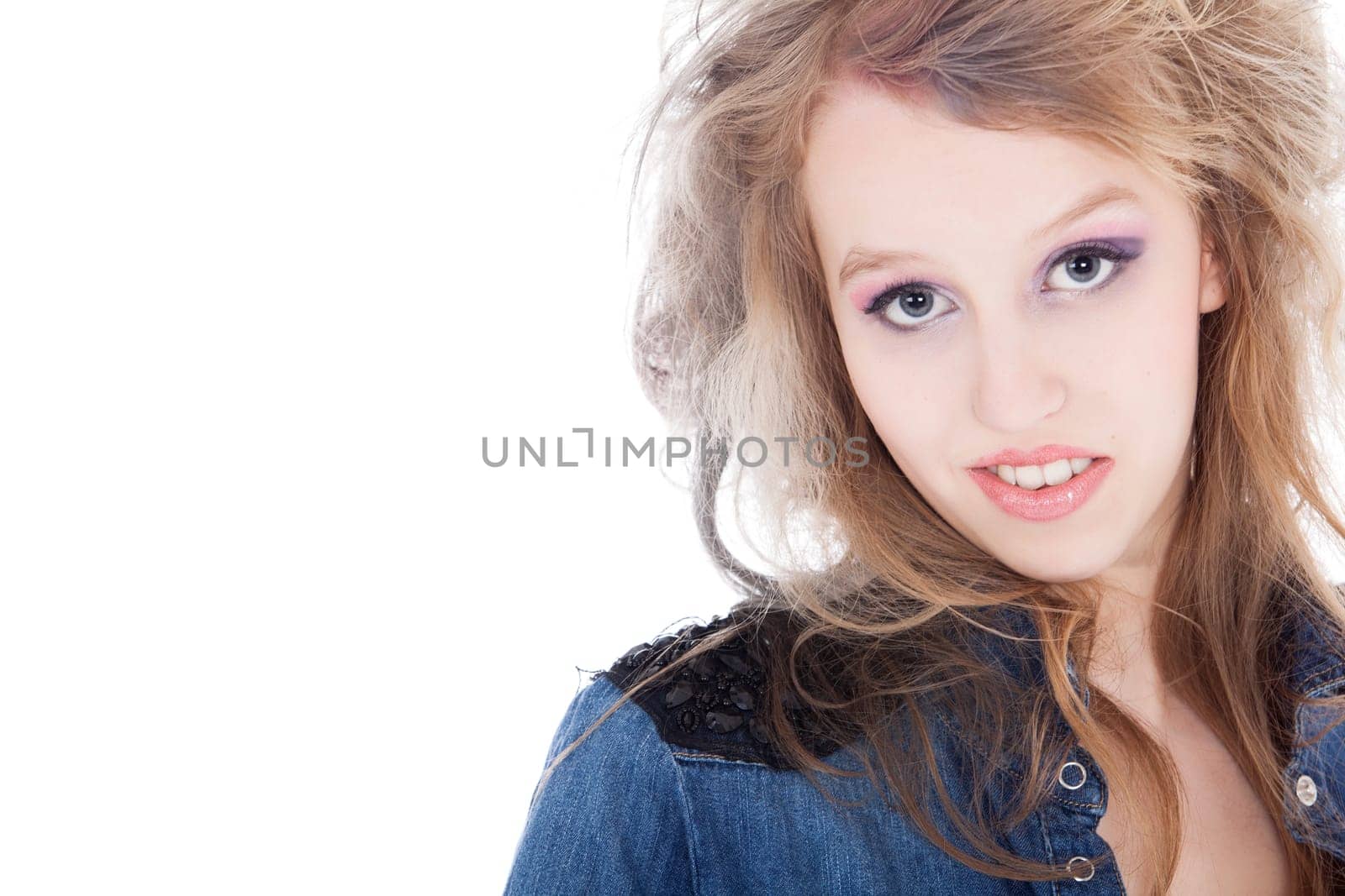 Young tough blond teenage girl with jeans blouse on a white background