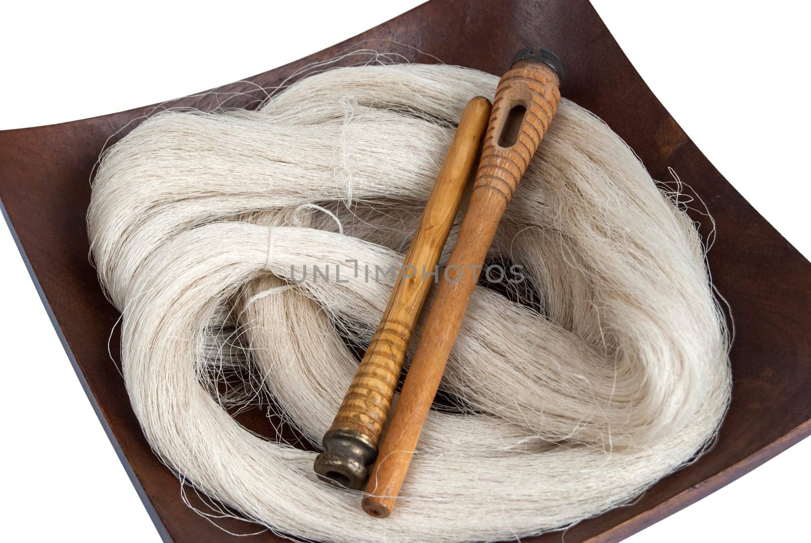 Raw silk yarn and spools of old loom in wooden platter